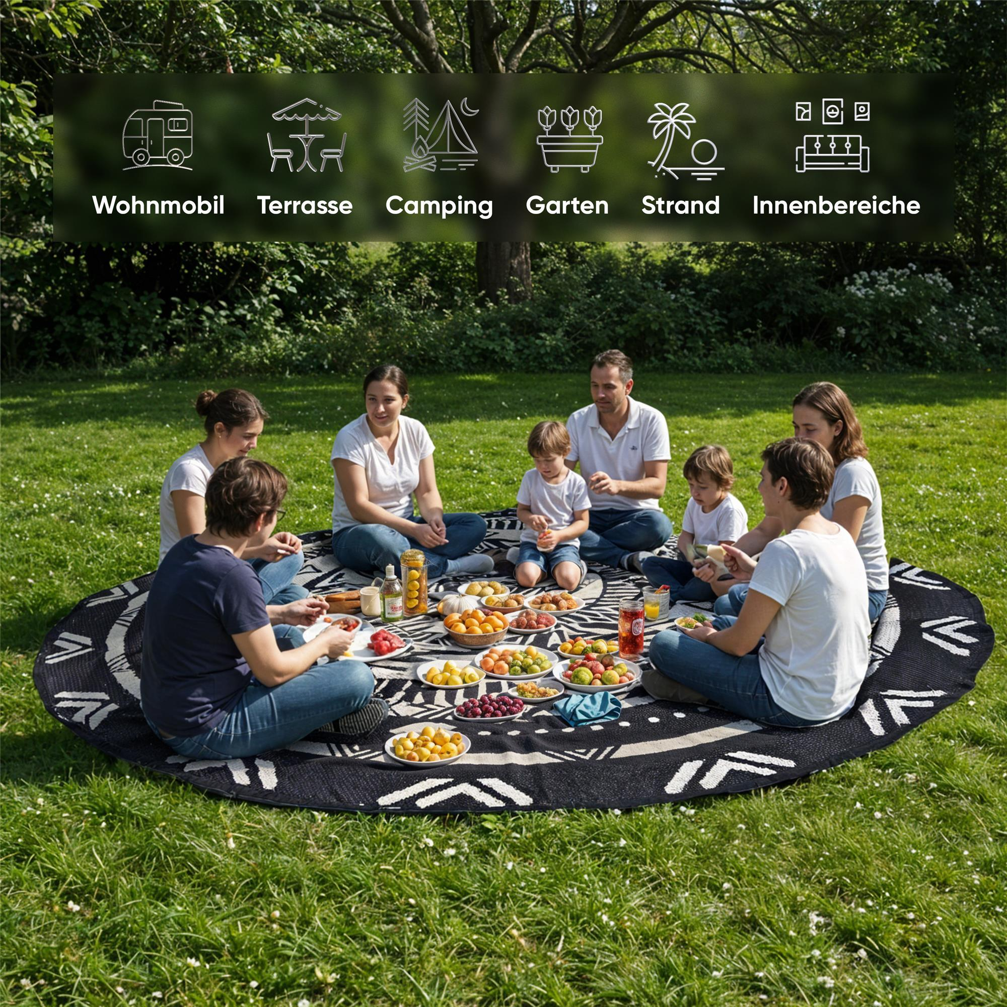 Eine Familie picknickt auf einer runden Decke im Gras, umgeben von Bäumen.