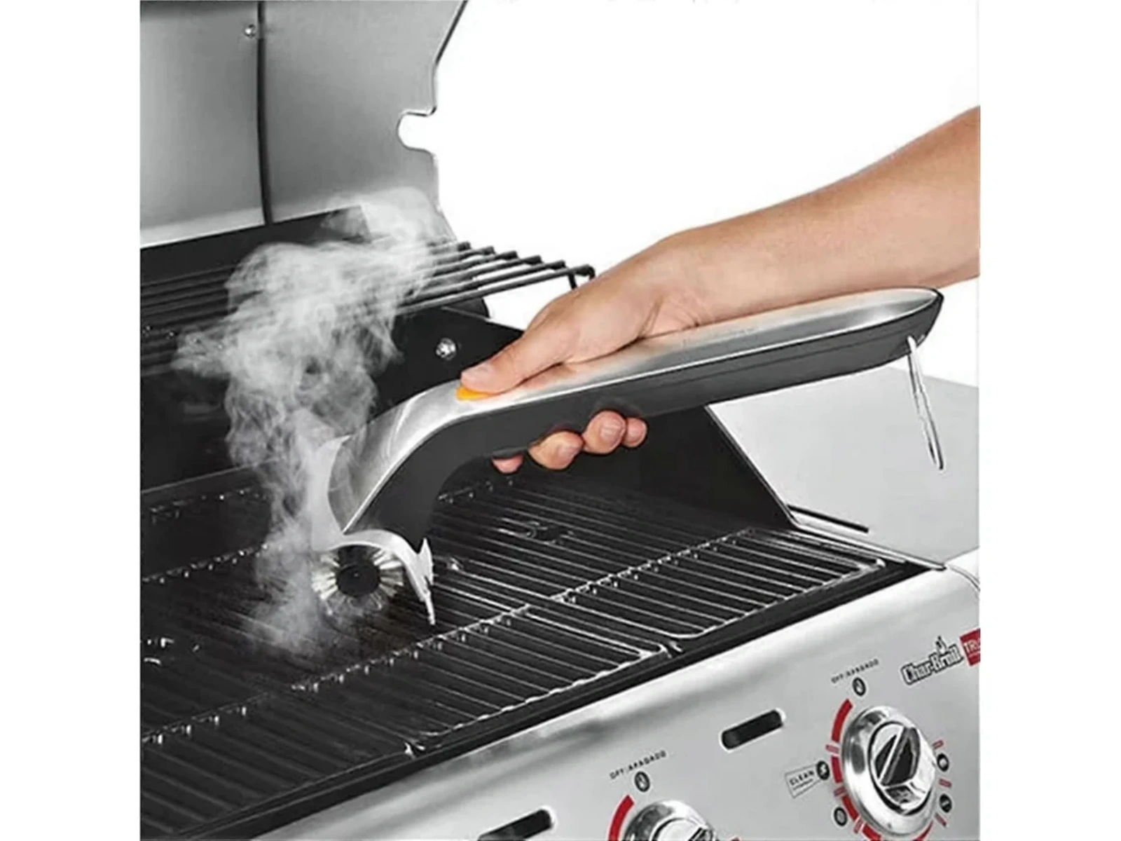 Dampfender Grillreiniger bürstet heiße Grillroste. Hand hält Werkzeug.