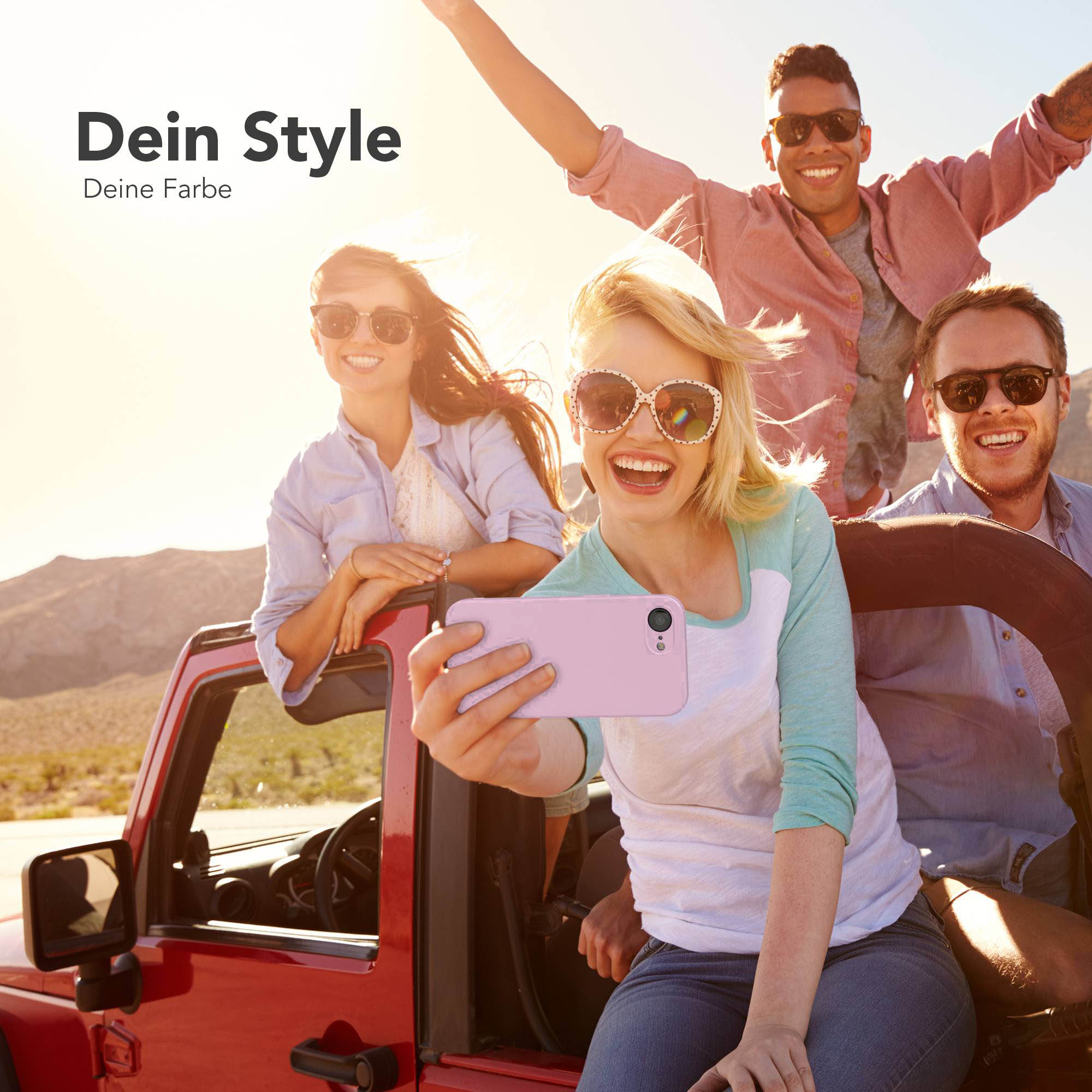 Vier Freunde im roten Jeep nehmen ein Selfie mit einem rosa Handy auf.