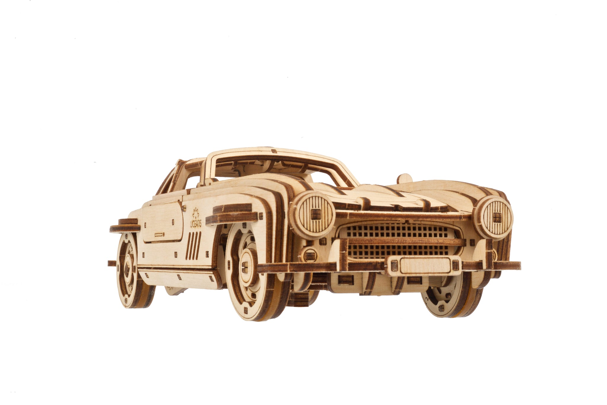 Un modello in legno di un'auto d'epoca convertibile su sfondo bianco.