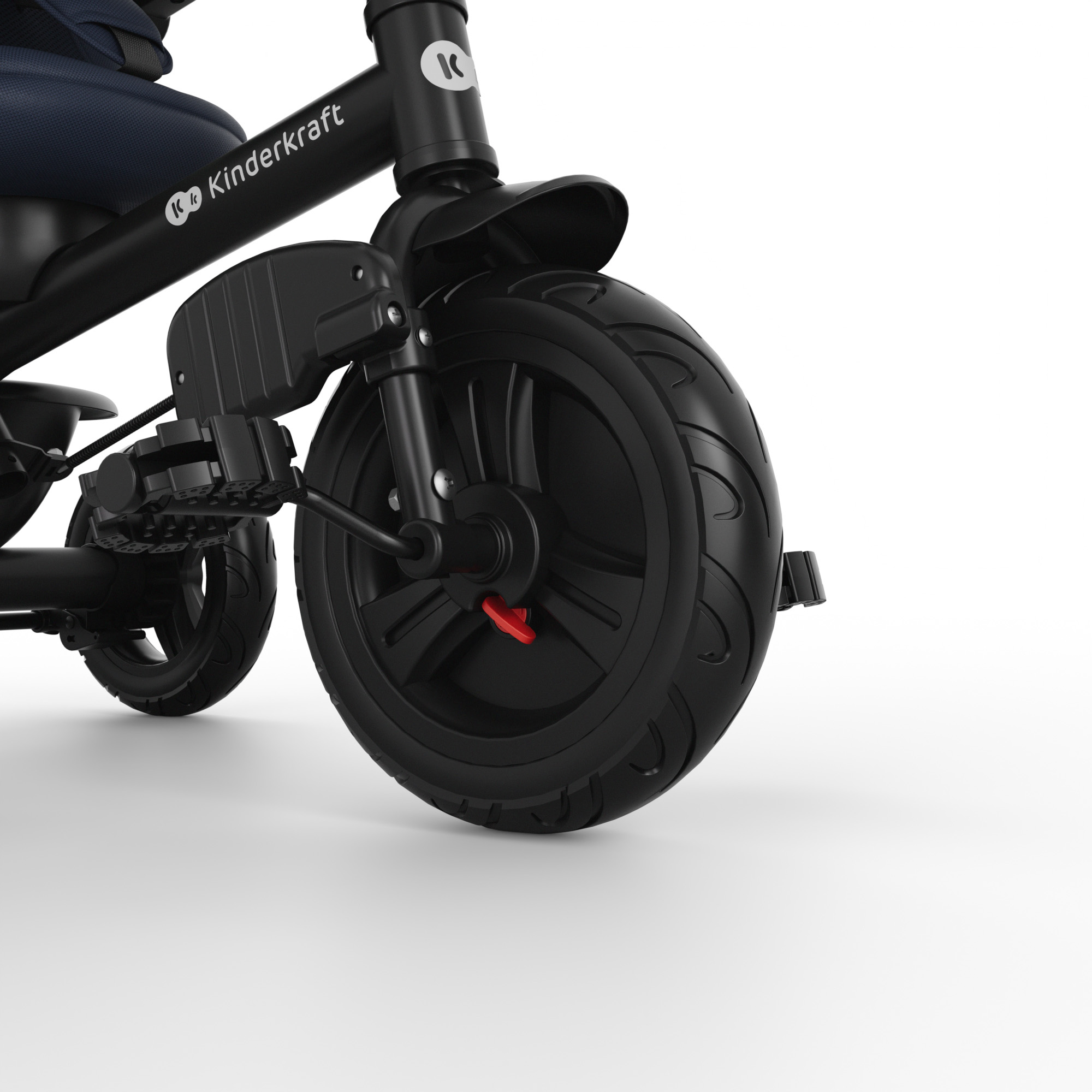 Primer plano de un triciclo negro con asiento infantil y suspensión.