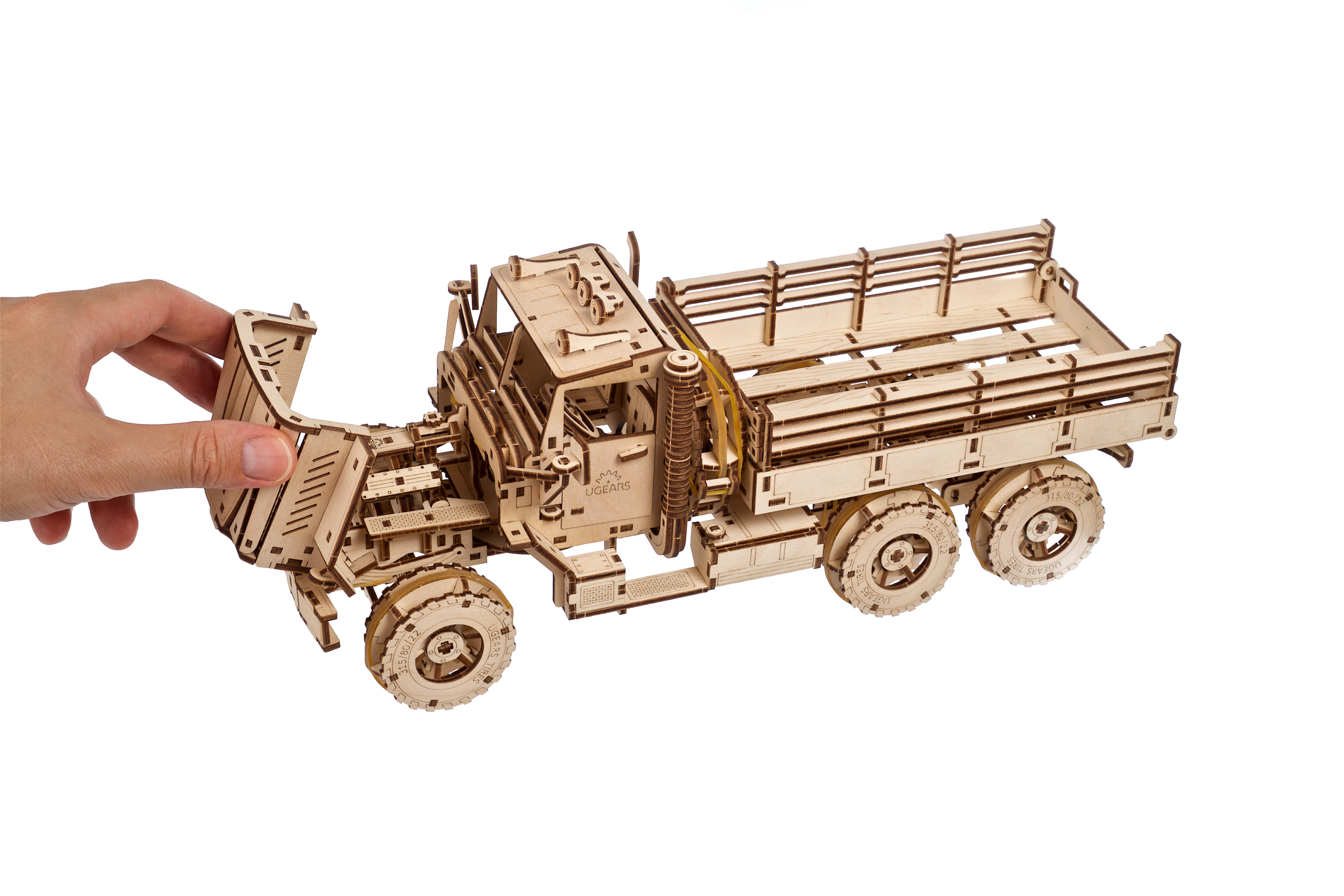 Ein hölzernes Modell eines Lastwagens, das von einer Hand gehalten wird.
