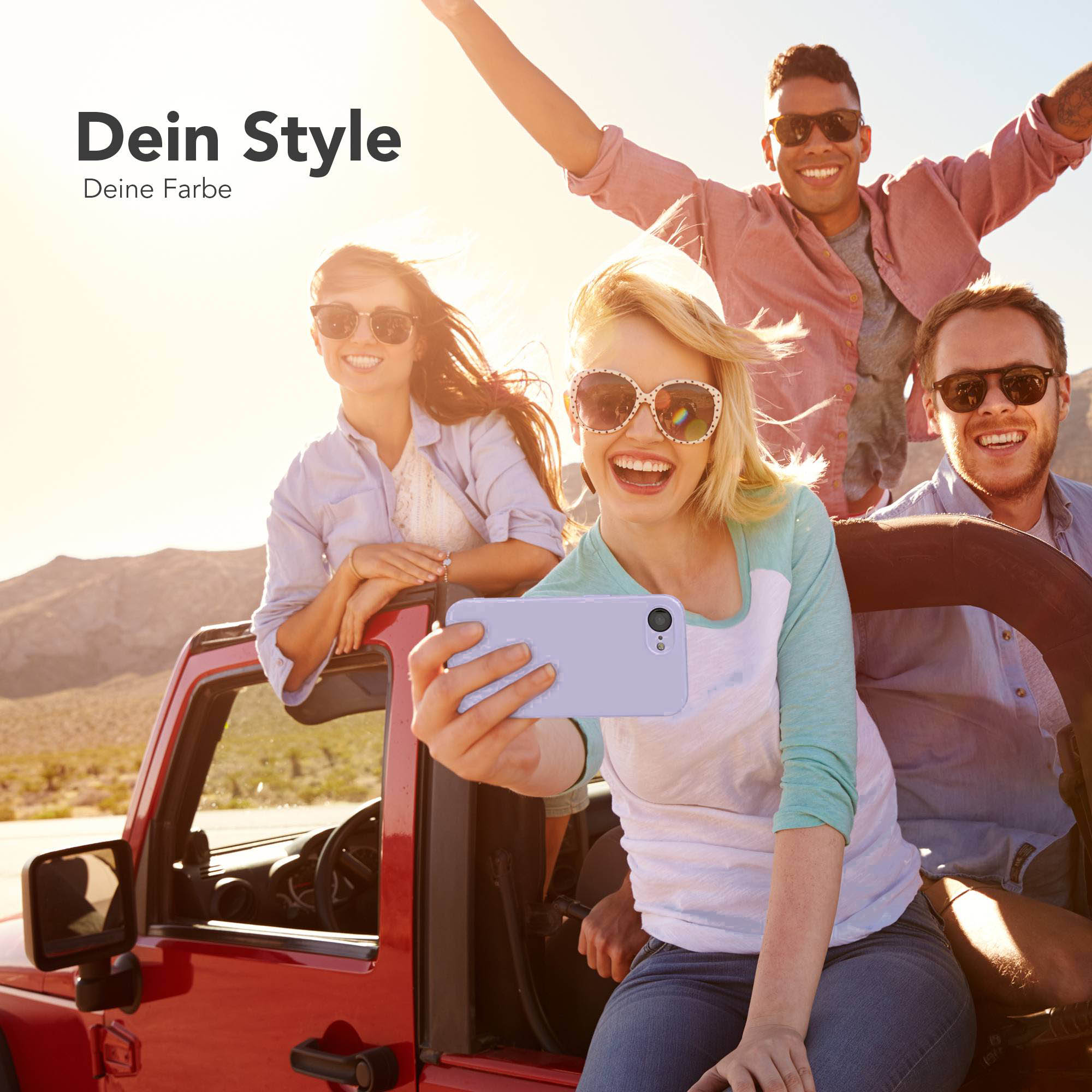 Vier Freunde in einem roten Jeep, die Sonne scheint, eine Frau macht ein Selfie.