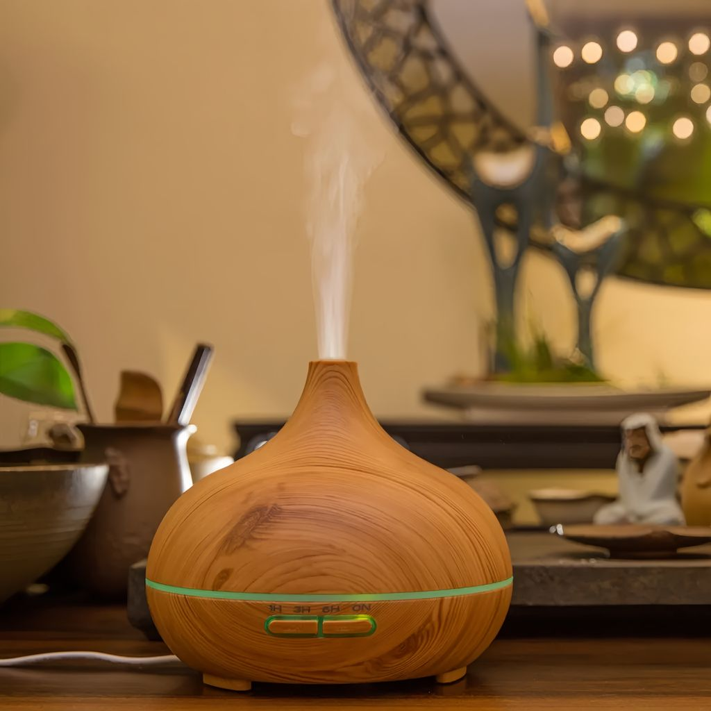 Ein hölzerner Diffusor für ätherische Öle stößt Nebel aus, mit einem grünen Lichtband und Knöpfen.