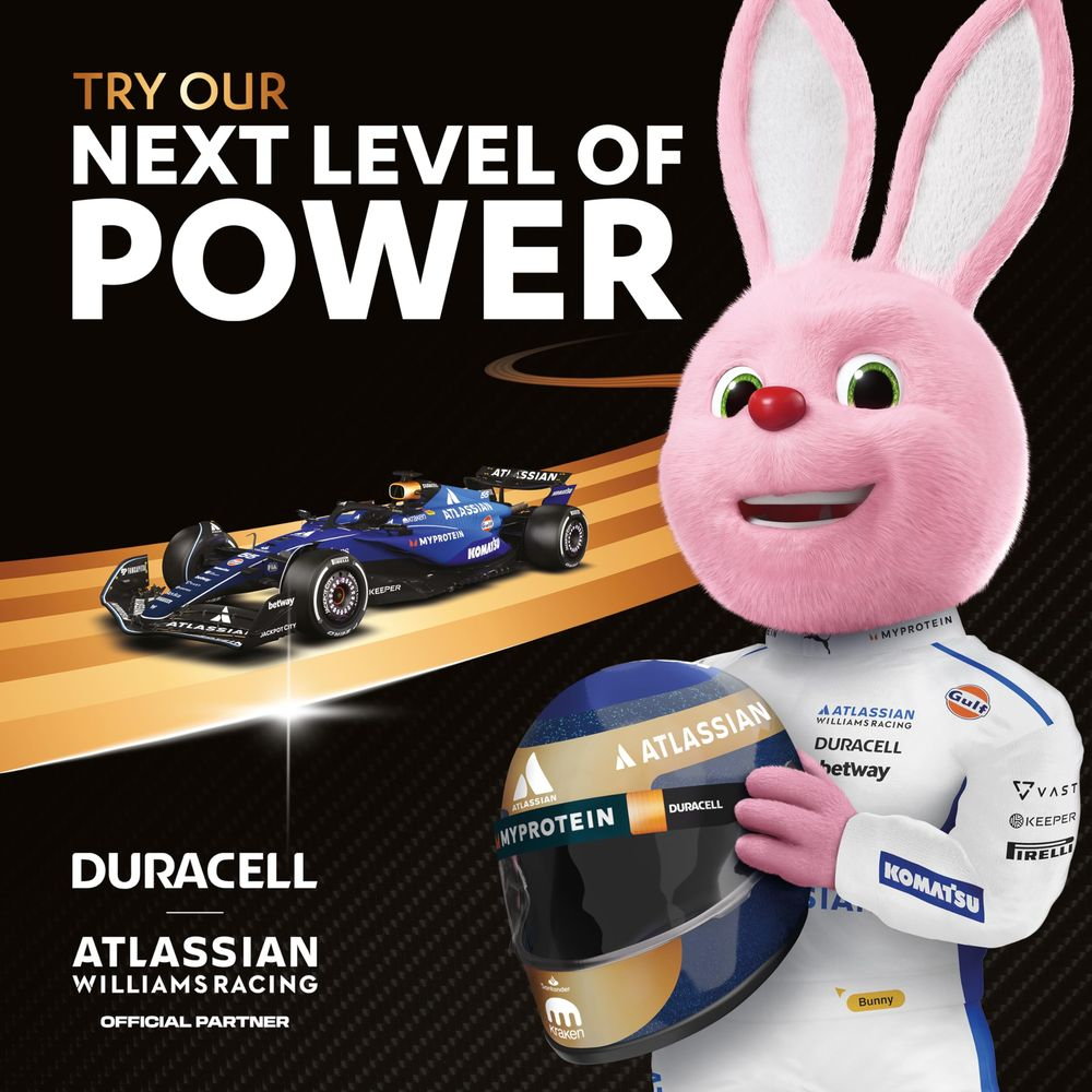 Lapin rose tient casque F1, voiture de course et marque Duracell.