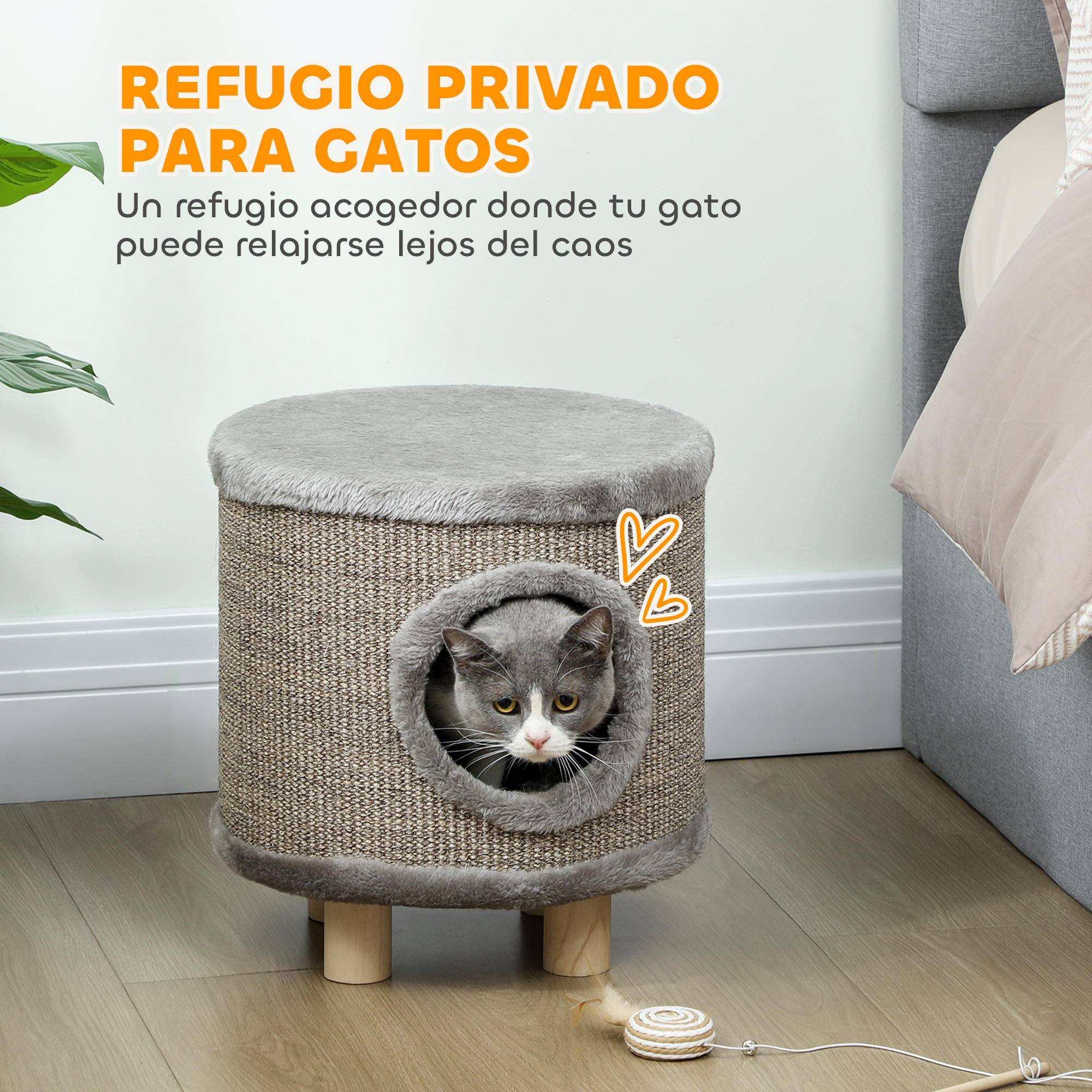 Torre de gato gris con abertura, un gato sentado dentro. Juguete en el suelo.