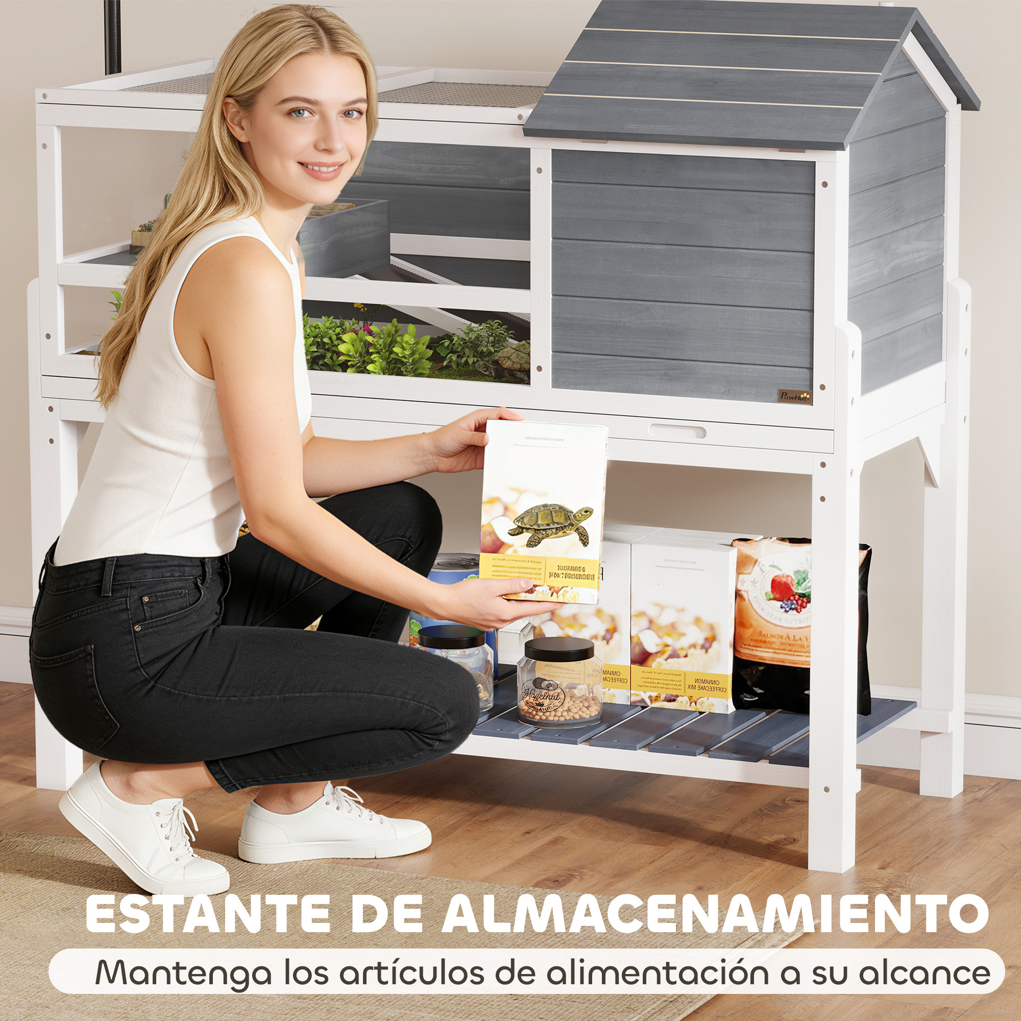 Una mujer se arrodilla frente a un recinto blanco y gris, sosteniendo un paquete de comida.