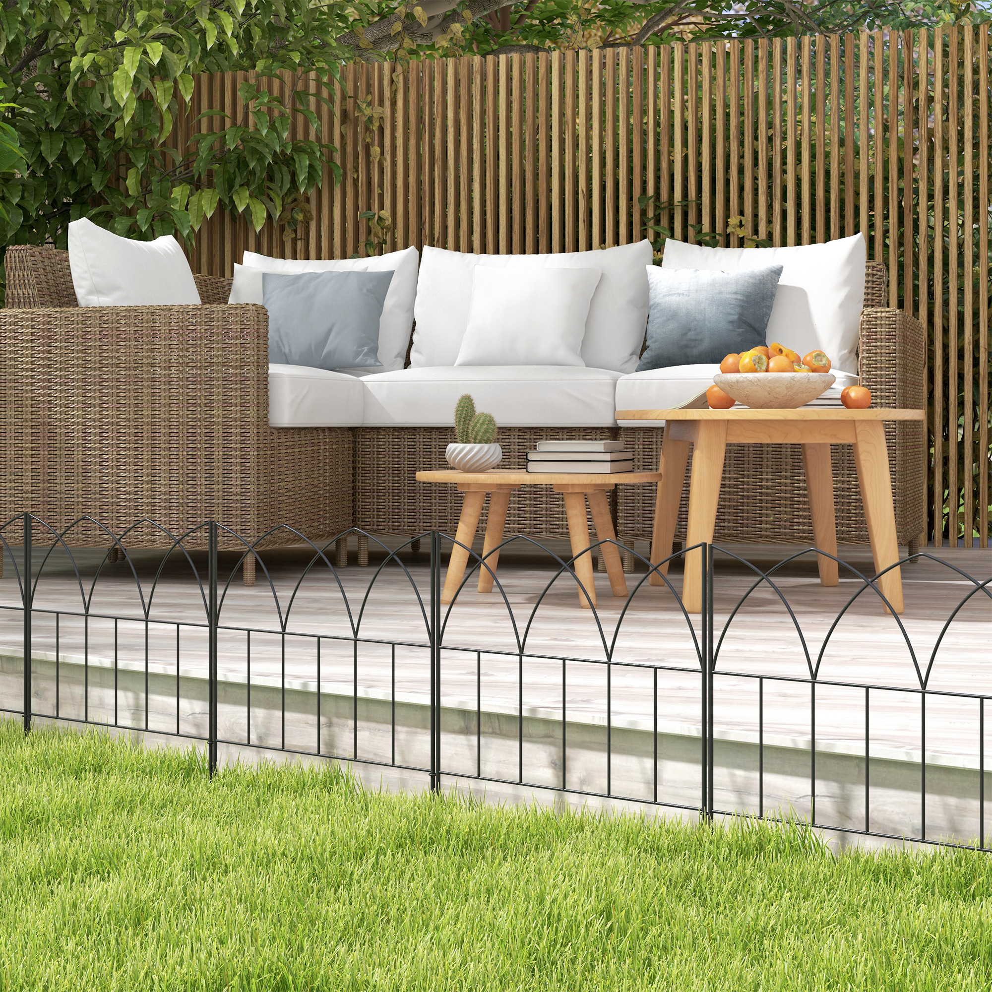 Muebles de exterior en una terraza de madera con césped y valla de madera.