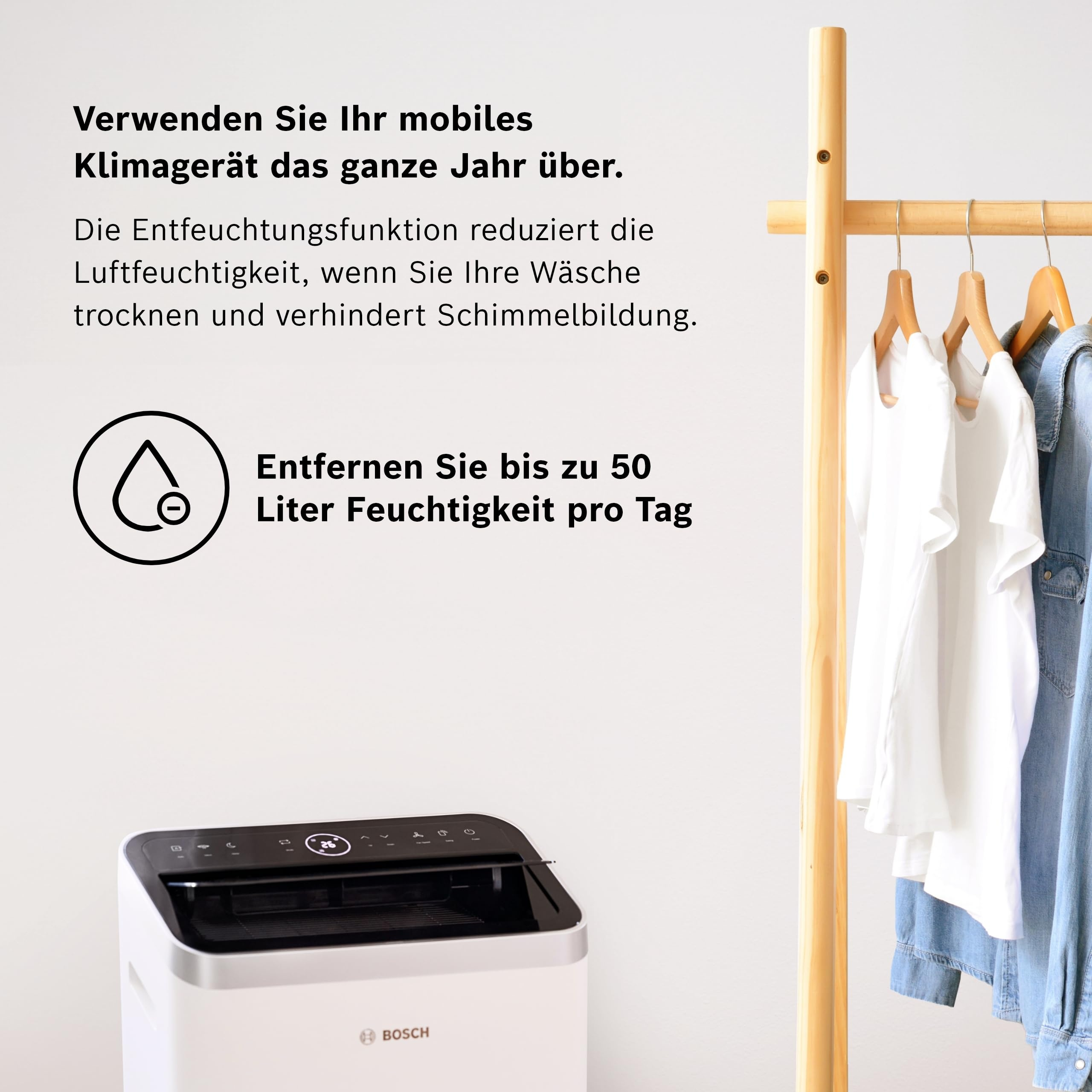 Een witte Bosch luchtontvochtiger met kleding op een houten rek.