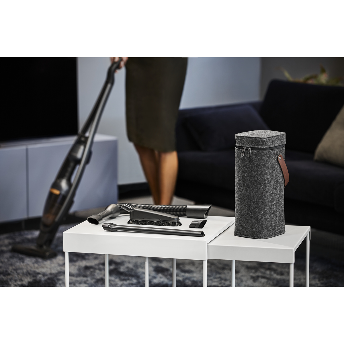 Un set de accesorios para aspiradora descansa sobre una mesa blanca, al lado una bolsa.
