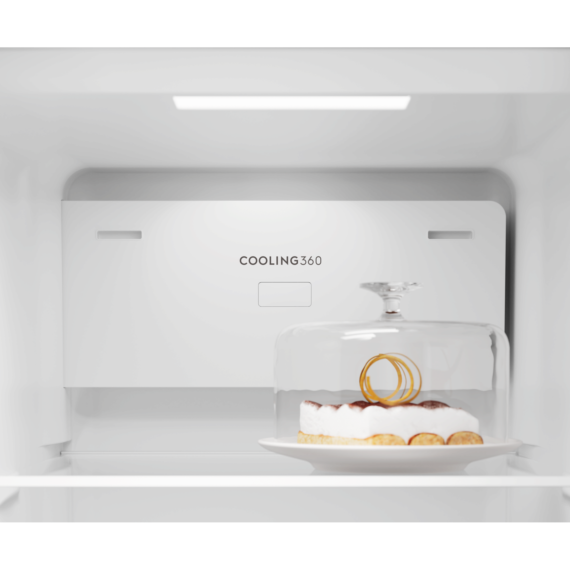 Un pastel bajo una campana de cristal en un refrigerador con texto COOLING360.