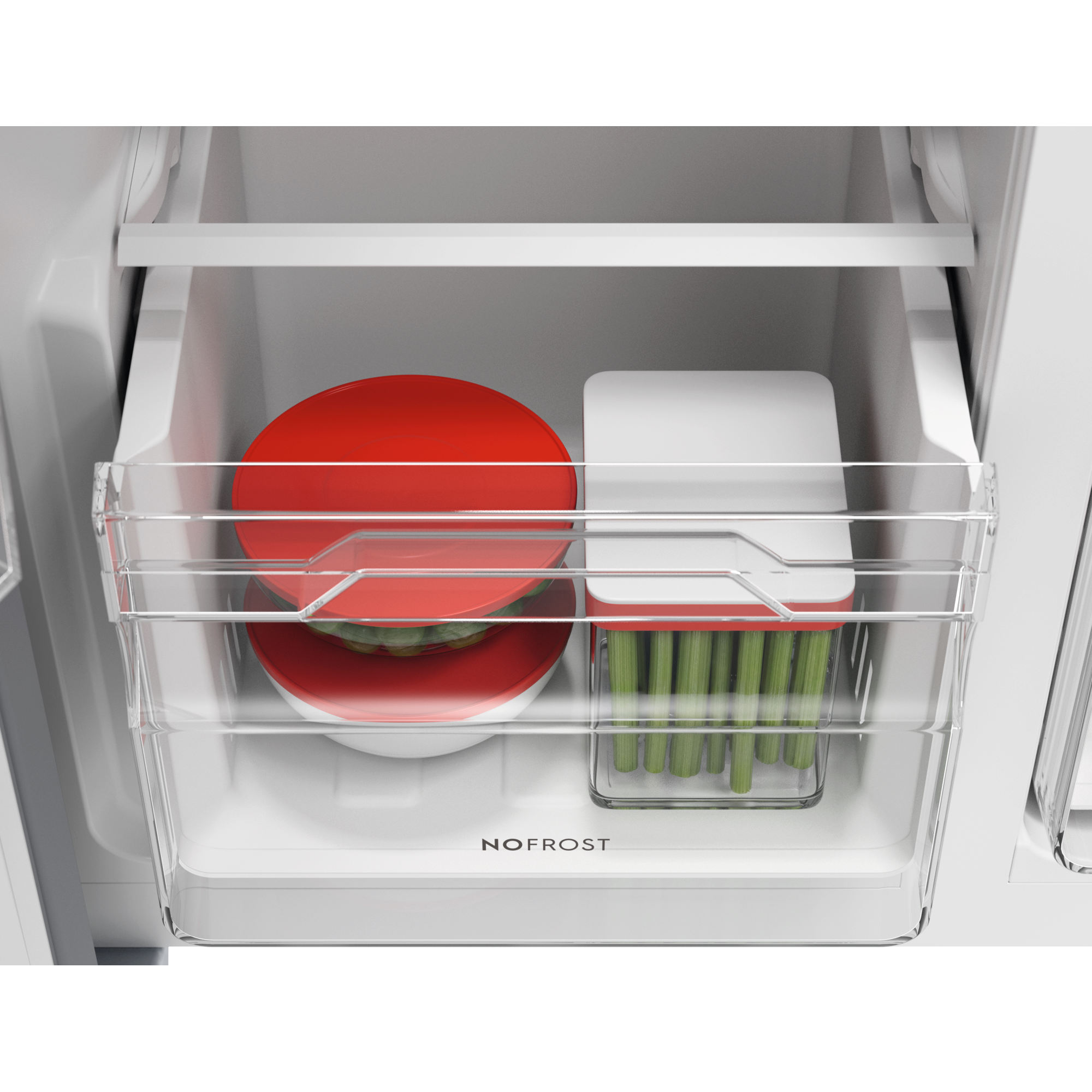 Dentro de un cajón de refrigerador: contenedor rojo con verduras y apio en caja transparente.
