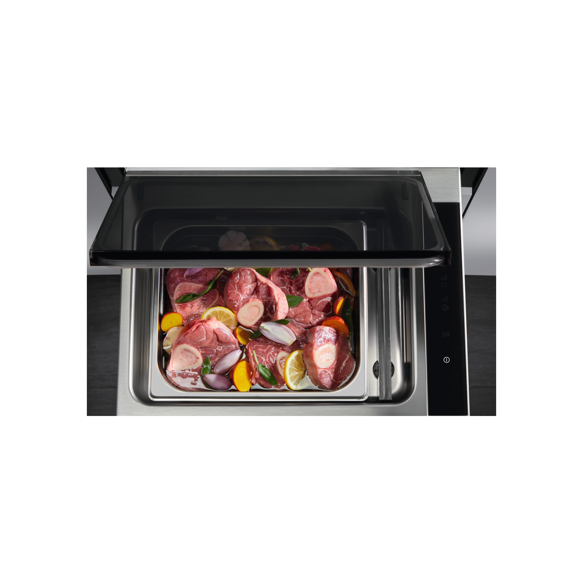 Carne cruda con verduras y rodajas de limón en una bandeja metálica dentro de un aparato.