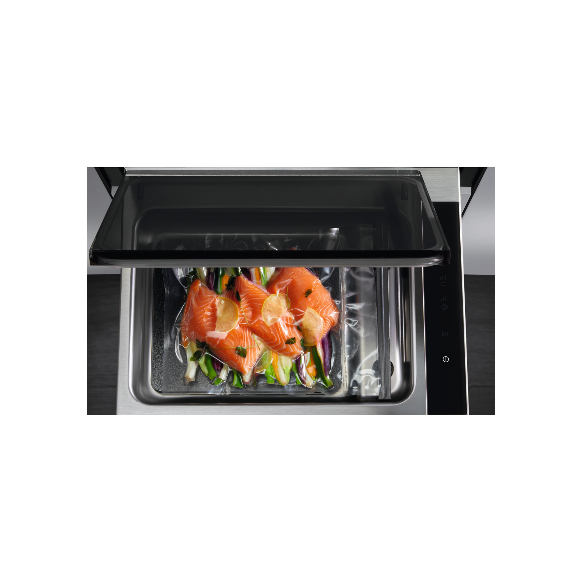 Filetes de salmón con verduras en bolsa de vacío dentro de una máquina de vacío.