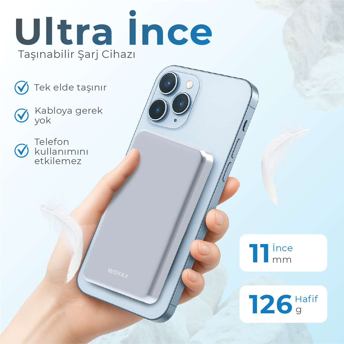 Bir el, arkasına ince, gri şarj cihazı takılı açık mavi bir akıllı telefon tutuyor.