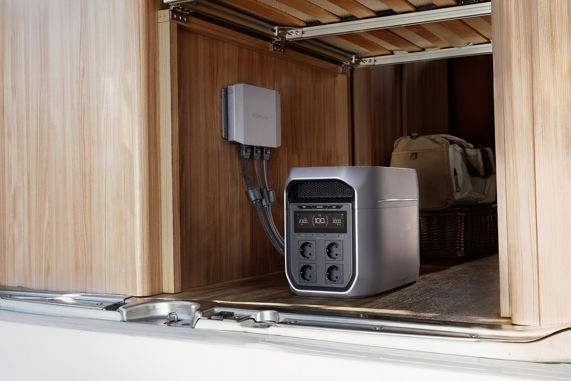Una central eléctrica gris con enchufes y un módulo EcoFlow están integrados en una autocaravana.