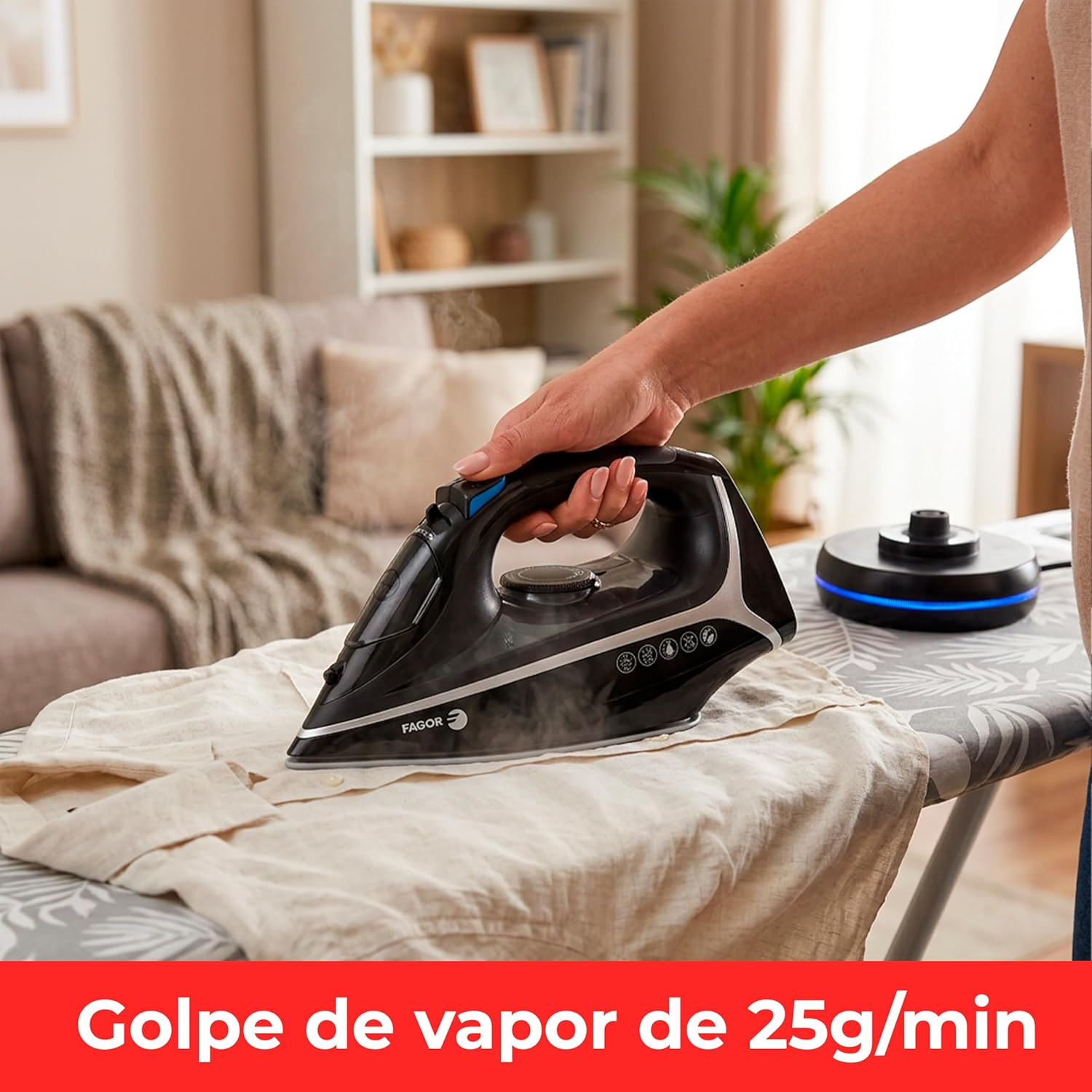 Una mano plancha una camisa clara con una plancha de vapor negra sobre una tabla.