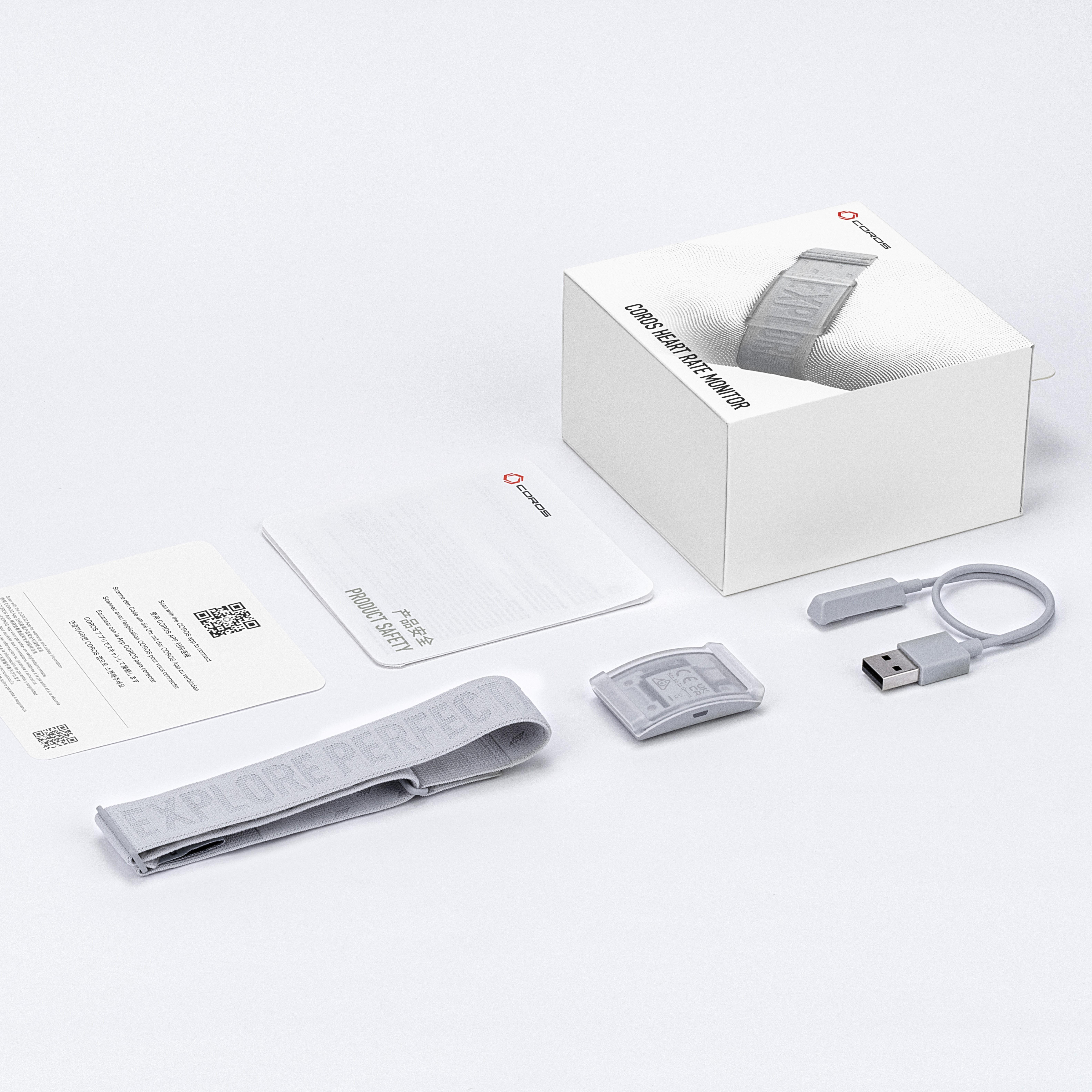 Un set di monitor cardiofrequenzimetro COROS con cinturino, sensore e cavo USB.