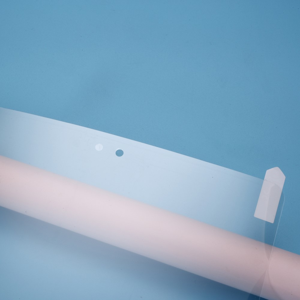 Un cylindre rose repose sur un fond bleu, partiellement recouvert de matière translucide.