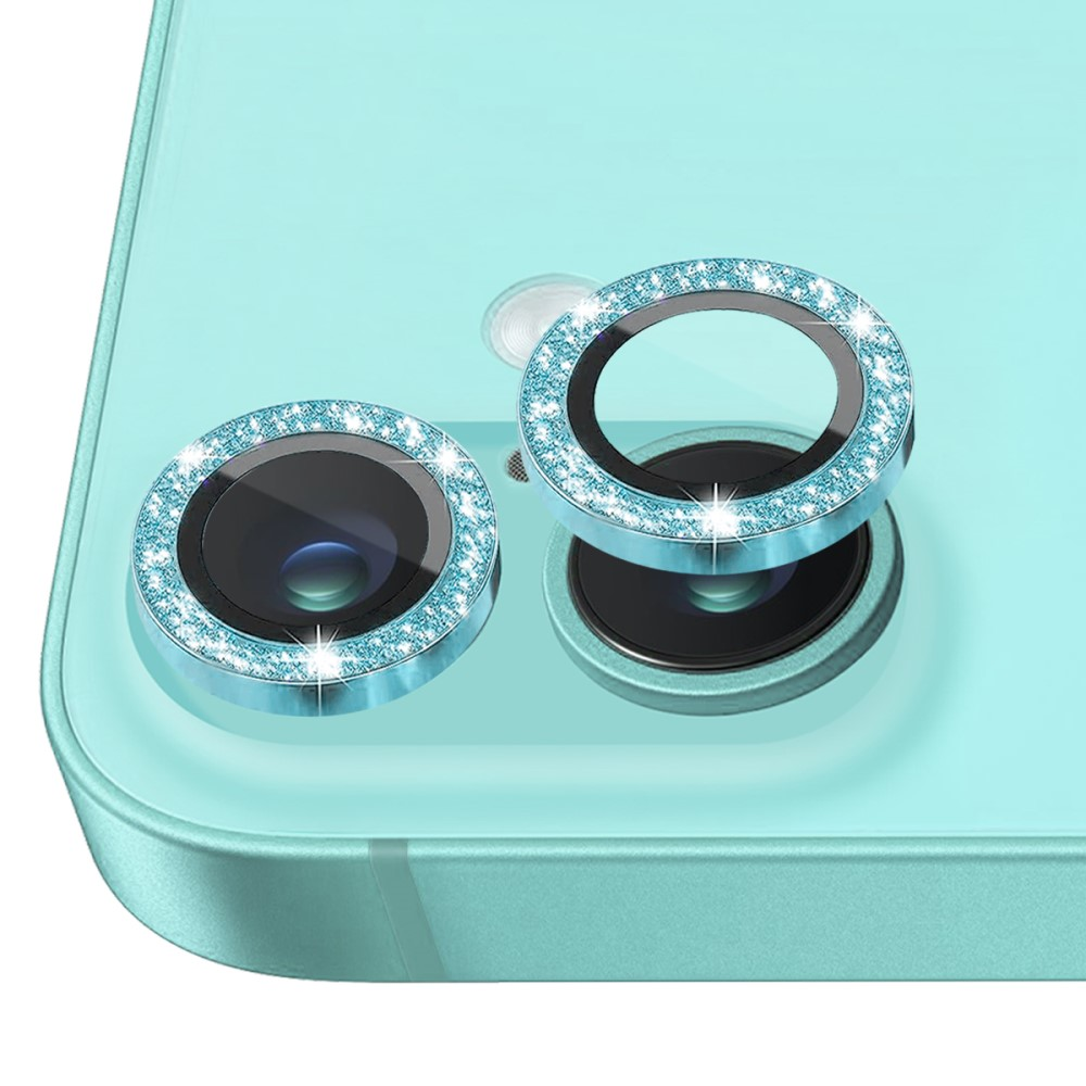Deux protecteurs d'objectif de caméra bleus, incrustés de strass, sur un smartphone turquoise.