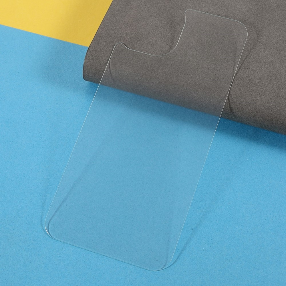 Un protecteur d'écran en verre transparent repose sur une surface bleue avec un fond gris et jaune.