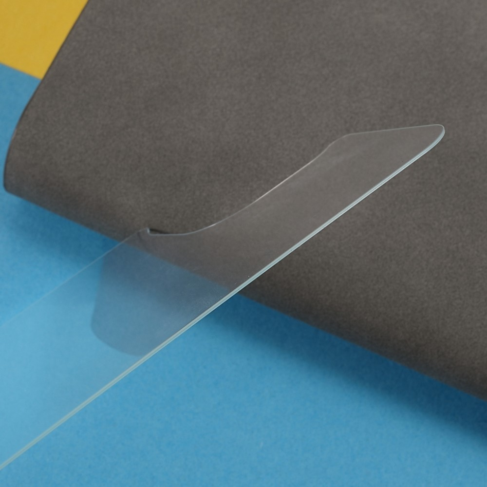 Un objet en plastique transparent repose sur un fond bleu et gris.