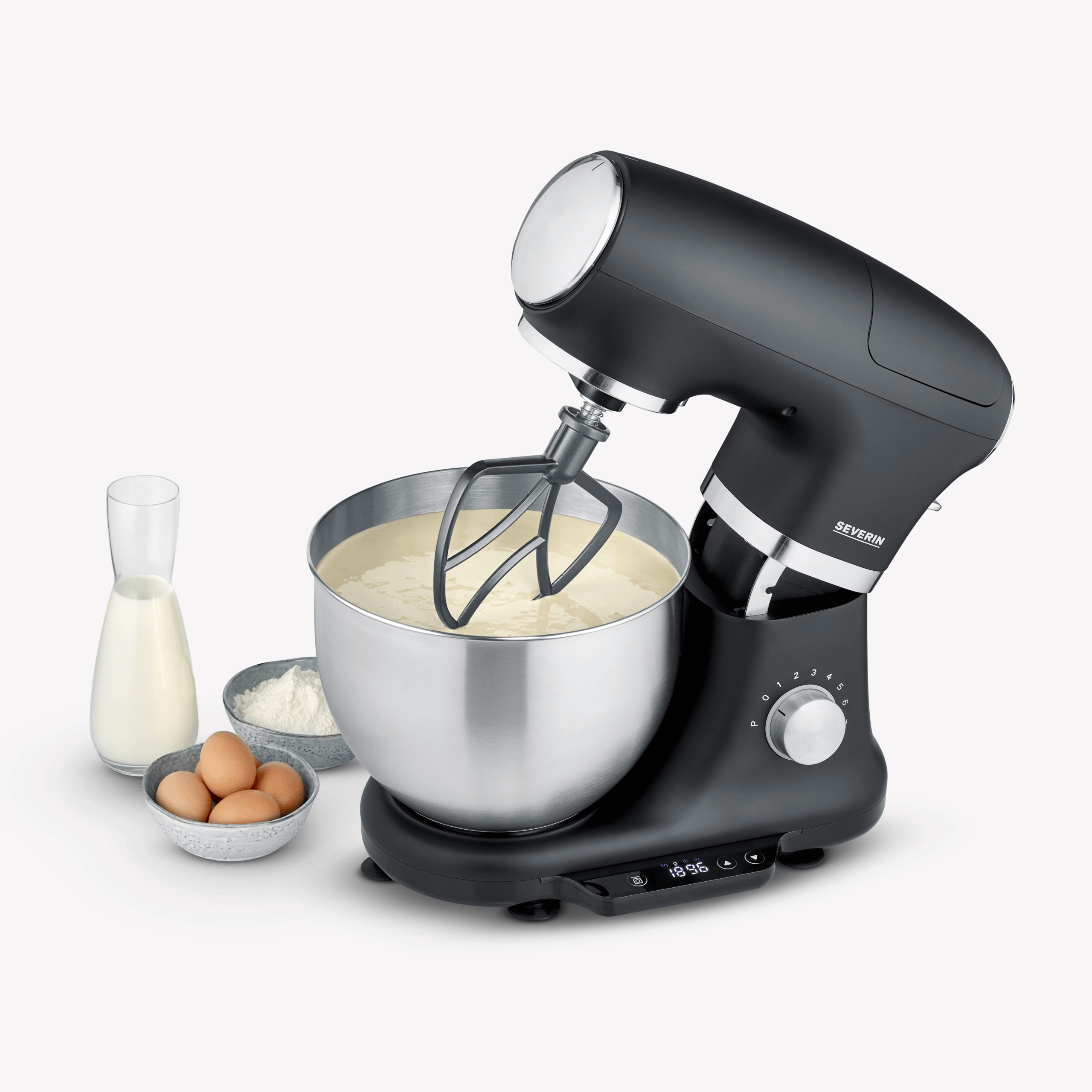 Schwarzer Küchenmixer mit Rührschüssel, Eiern, Mehl und Milch.