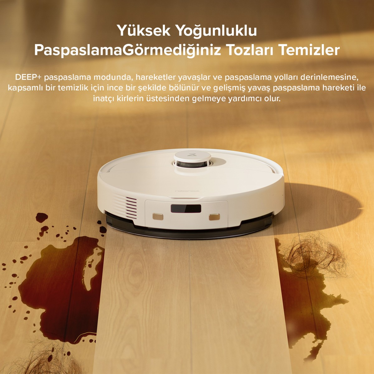 Ahşap zeminde sıvı dökülmüş ve saç olan beyaz robot süpürge.