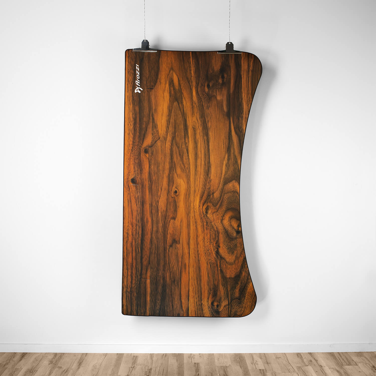 Un pannello di legno marrone scuro con venature, appeso a un muro bianco.