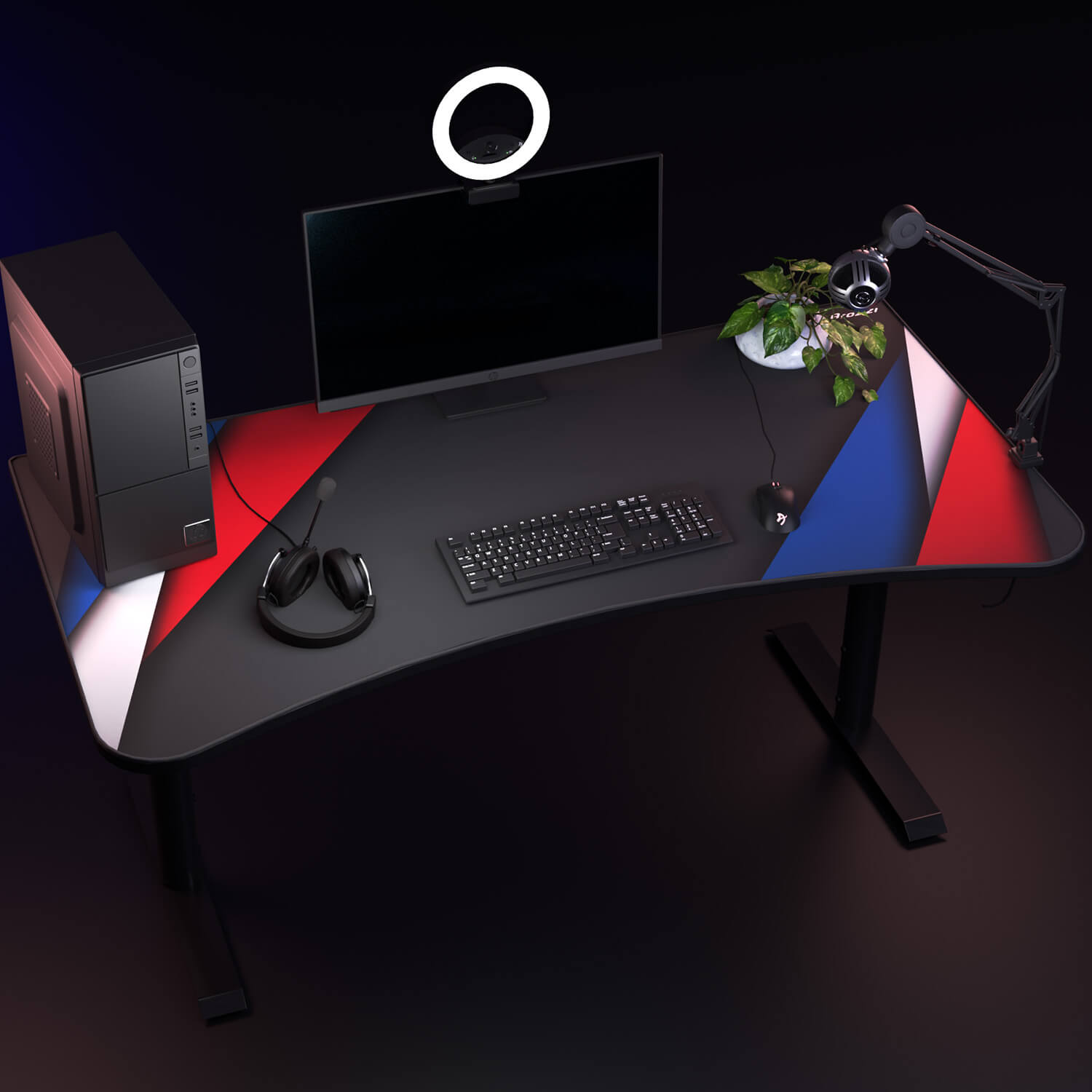 Una scrivania con computer, monitor, tastiera, mouse, cuffie, microfono e pianta.