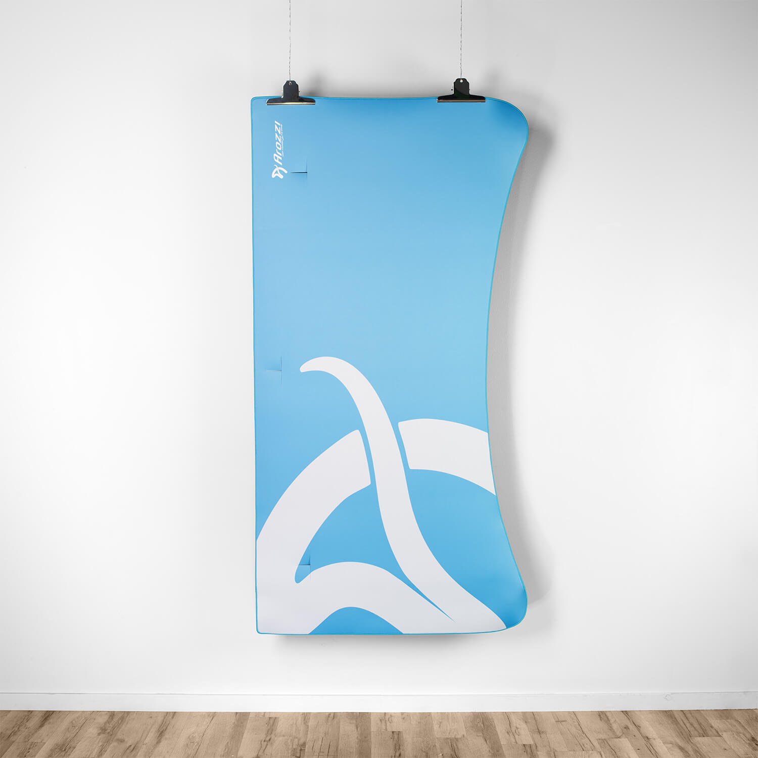 Un banner azzurro con logo bianco è appeso a una parete bianca.