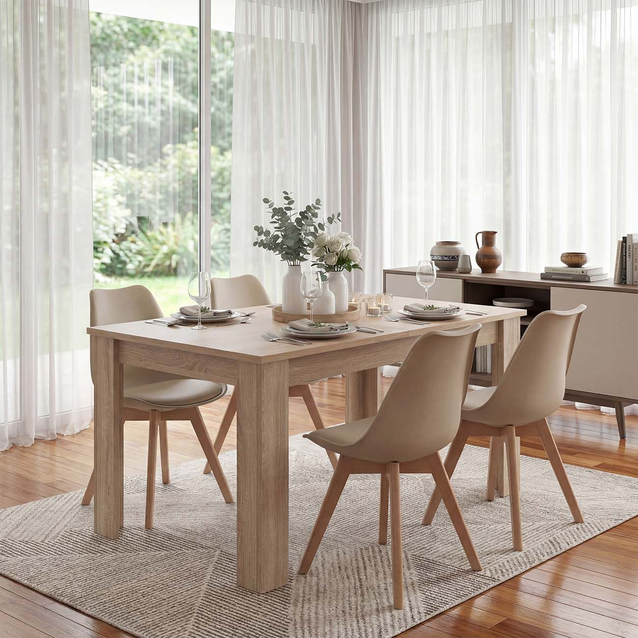 Una mesa de comedor de madera clara con cuatro sillas y servicios, sobre una alfombra.