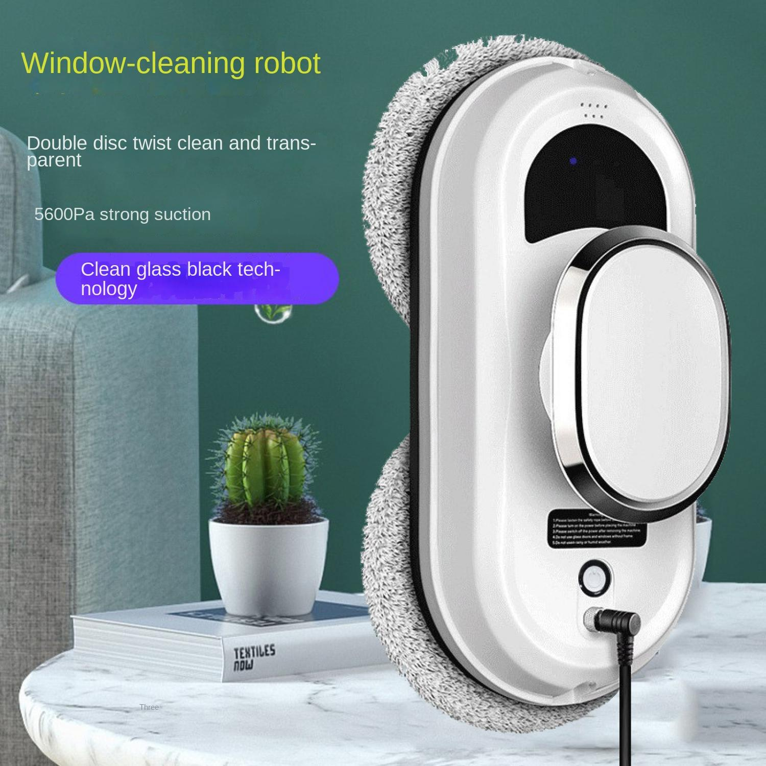 Ein weißer Fensterreinigungsroboter mit einem runden Wischaufsatz auf einem Tisch neben einer Pflanze.
