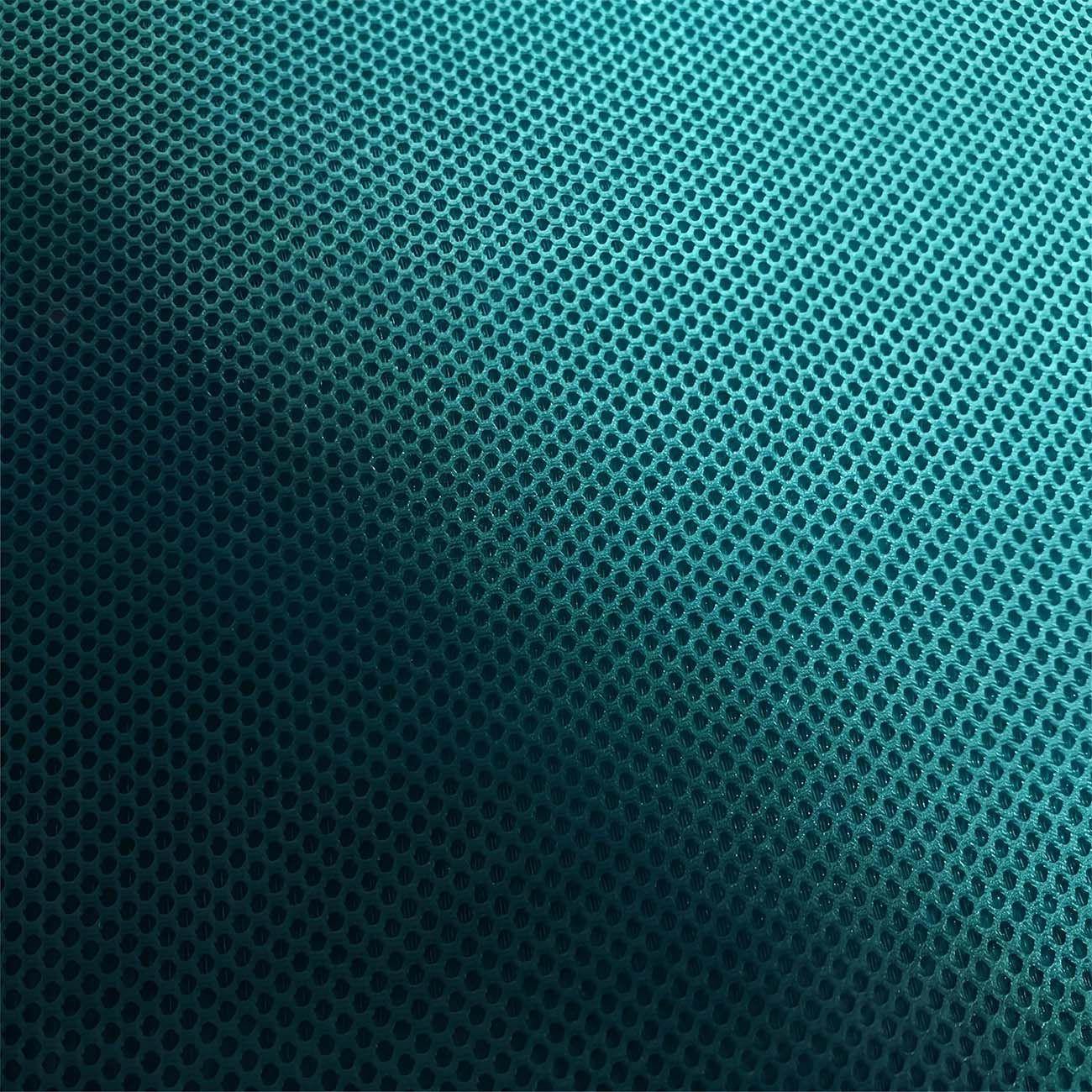 Tejido verde azulado con pequeños agujeros hexagonales, más oscuro a la izquierda.