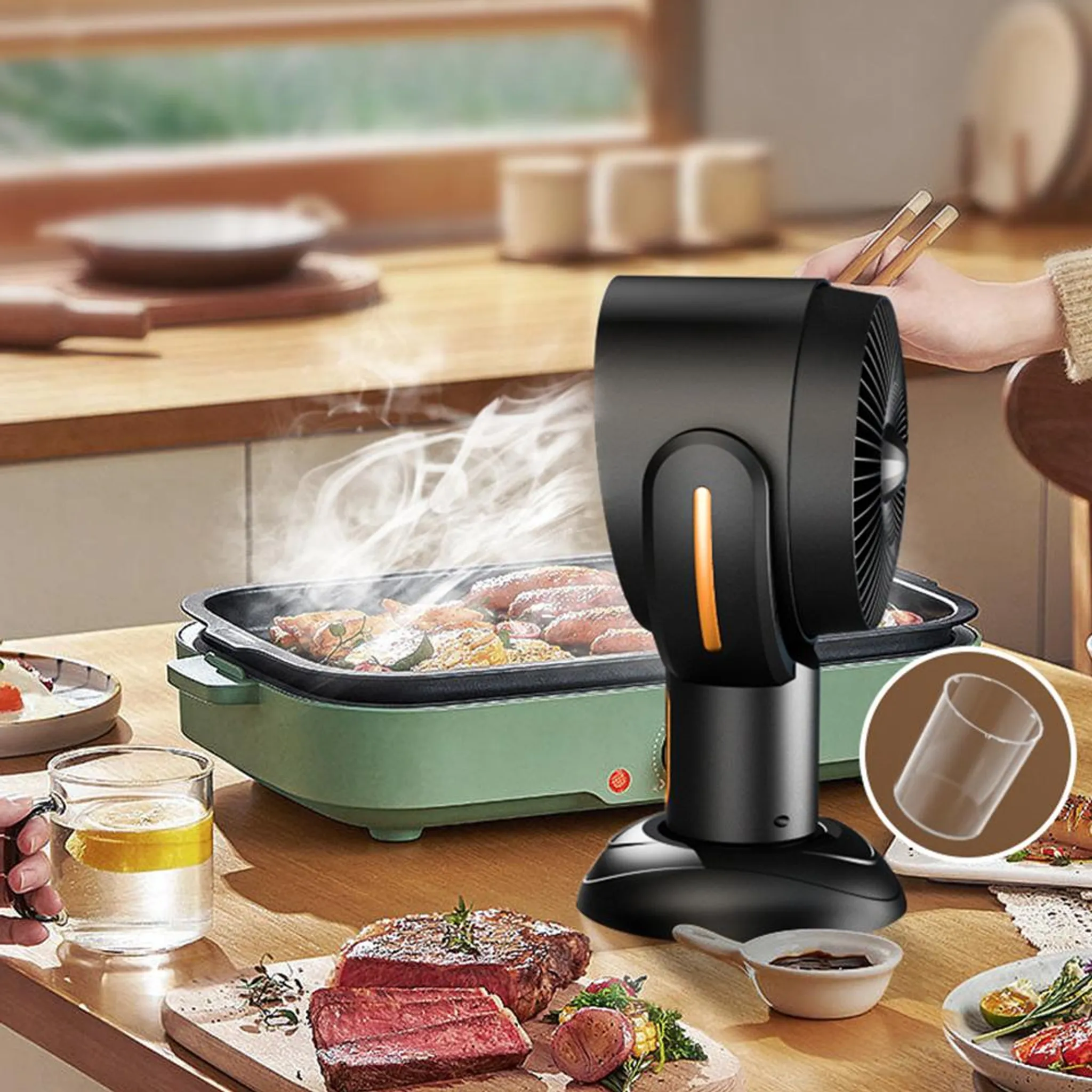 Ein schwarzer Lüfter steht auf einem Tisch mit Essen, darunter gegrilltes Fleisch und eine Tasse.