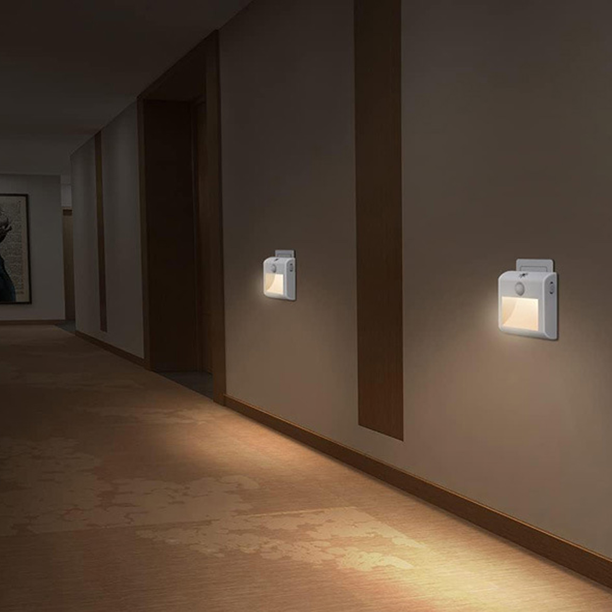 Zwei weiße Nachtlichter leuchten an einer Wand in einem dunklen Flur.