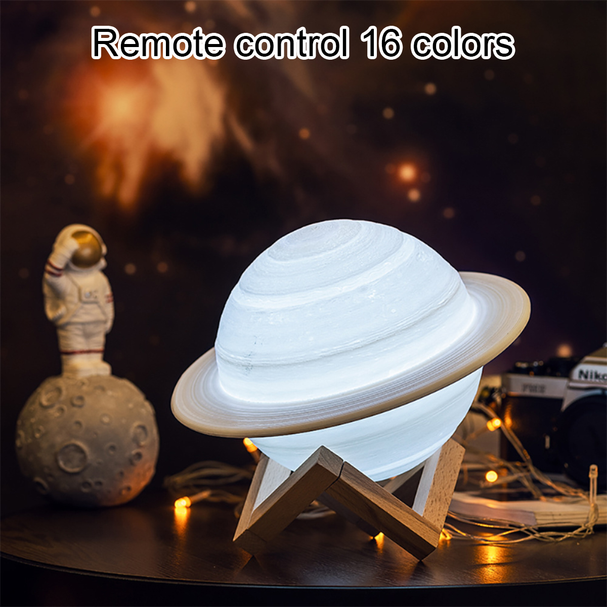 Eine Planet Lampe mit Saturnringen auf einem Holzständer, neben einem Astronauten auf dem Mond.