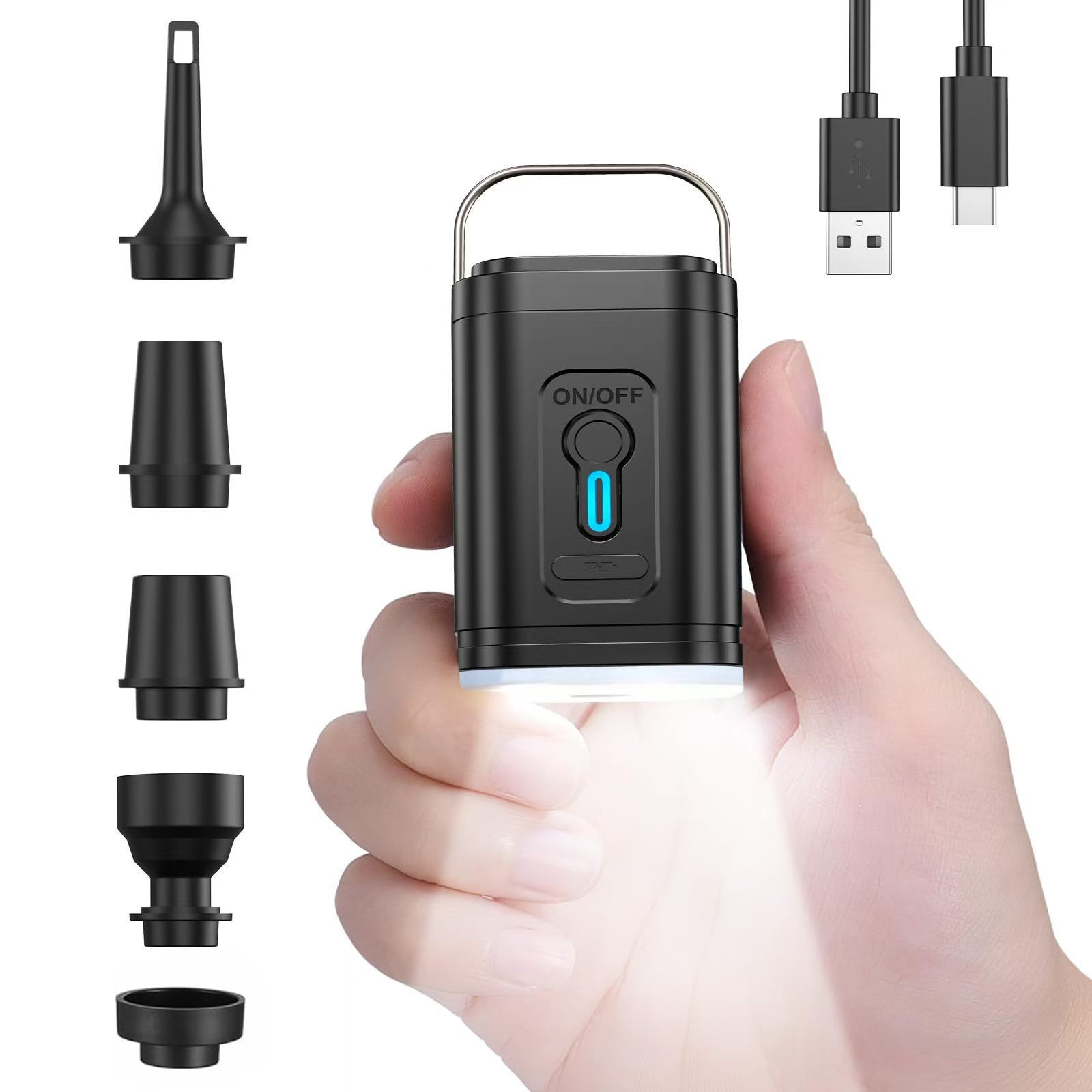 Eine Hand hält eine schwarze Luftpumpe mit USB-Kabel und verschiedenen Aufsätzen.