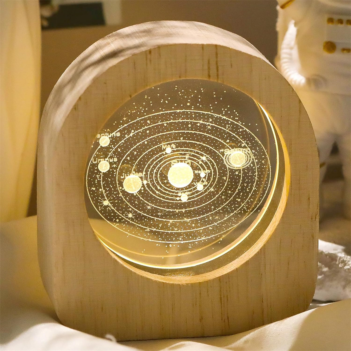Ein Holzrahmen beleuchtet ein Sonnensystem-Modell mit Sternen.