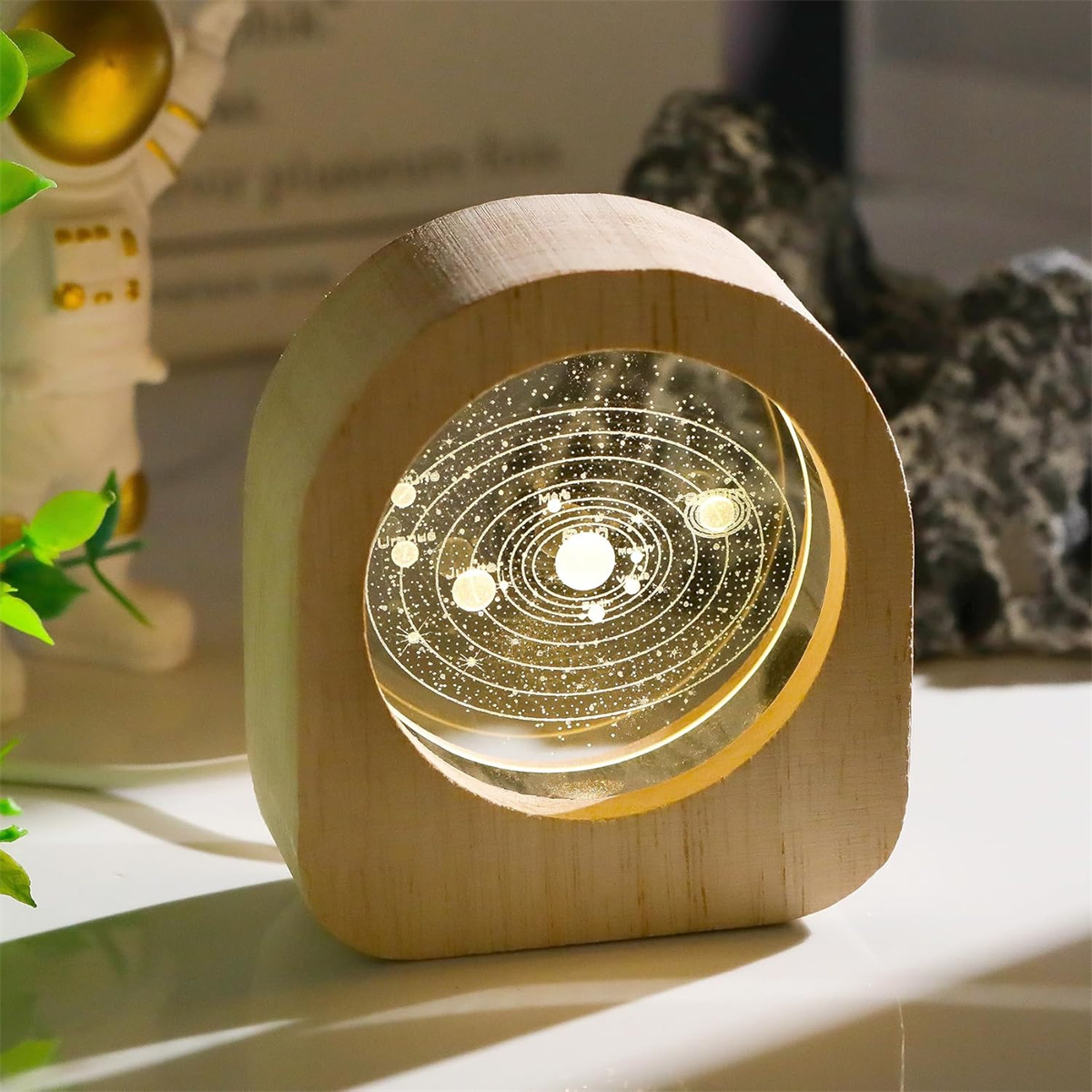 Holzlampe mit Sonnensystem-Gravur und Sternenhintergrund.
