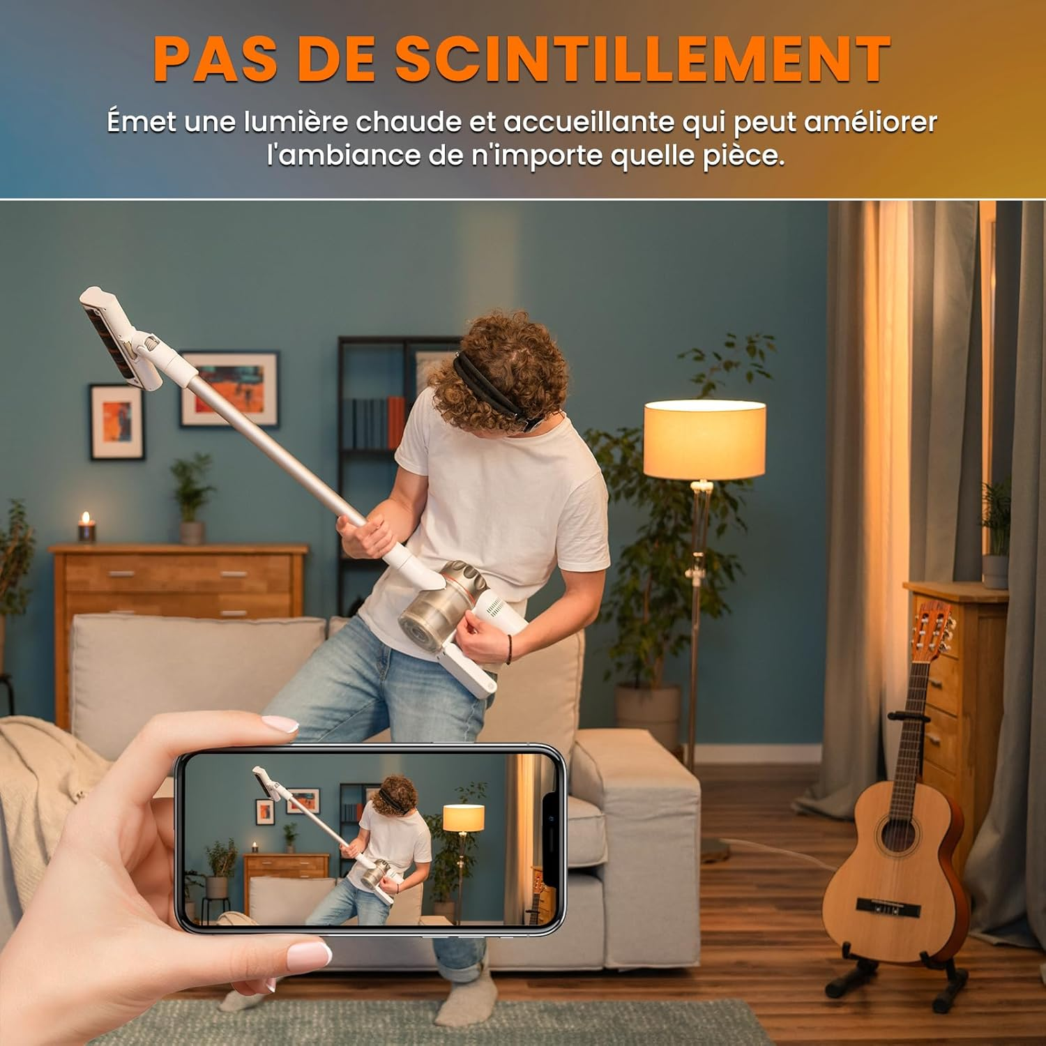Mann hält Staubsauger wie Gitarre; Handy filmt ihn.