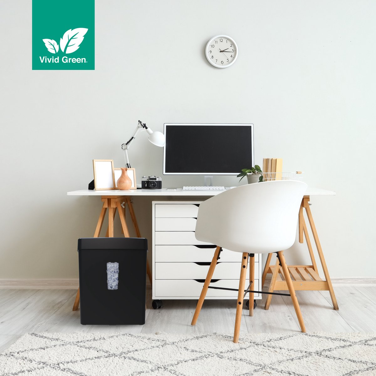 Un bureau avec ordinateur, lampe et destructeur.