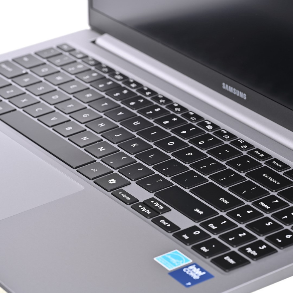 Zbliżenie srebrnej klawiatury i krawędzi ekranu laptopa Samsung, z naklejką Intel Core.