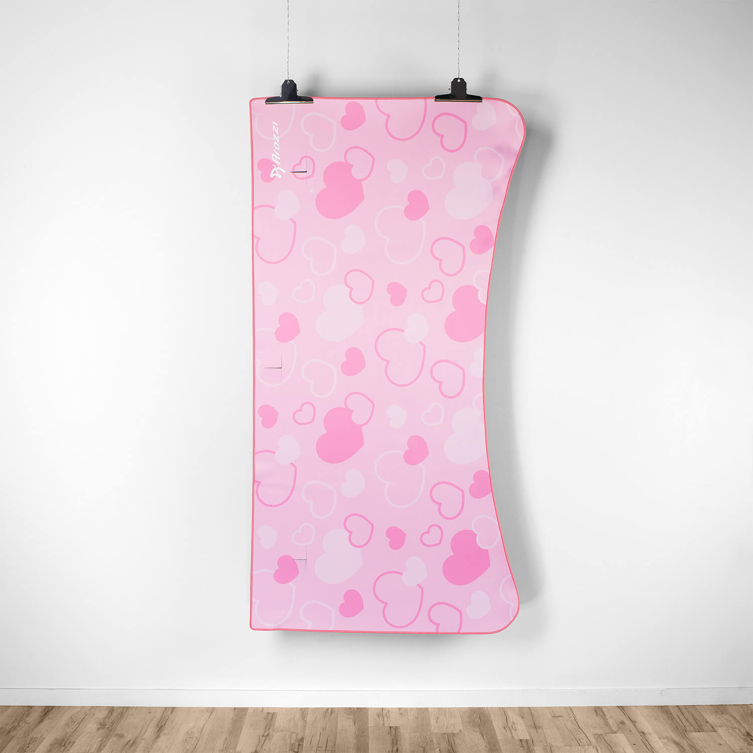 A pink mat with a heart pattern hangs on the wall.