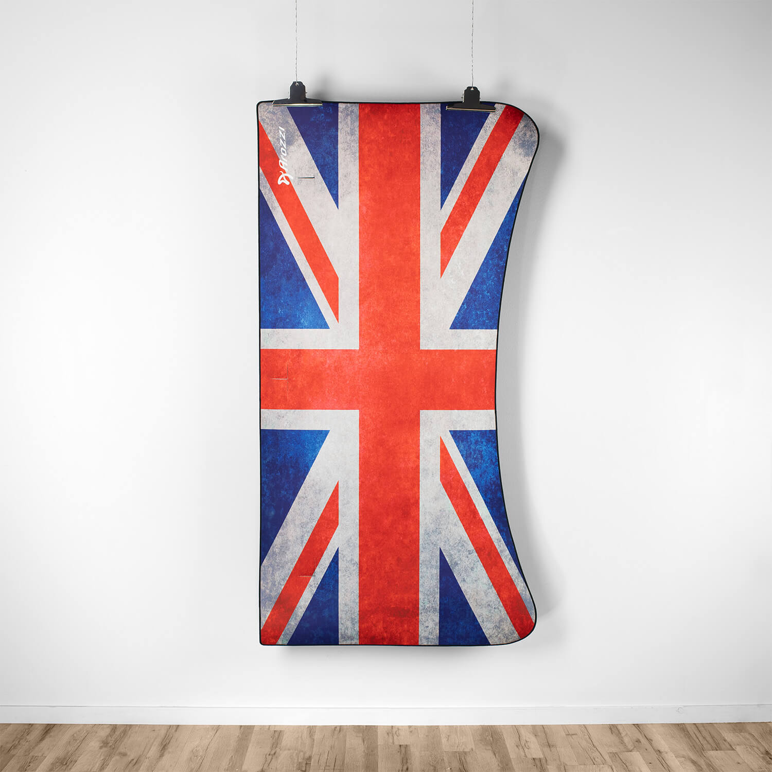 Una bandiera Union Jack dall'aspetto usurato, appesa a una parete bianca.