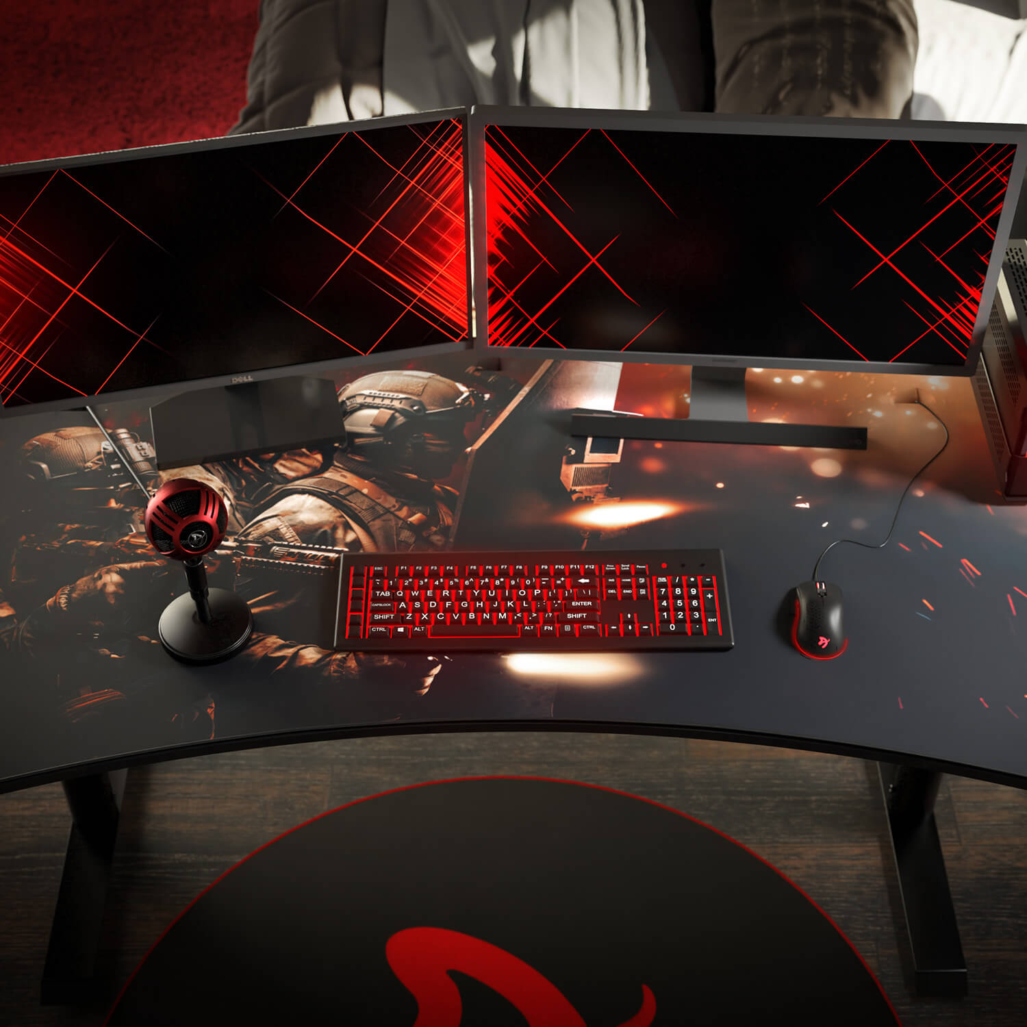 Doppio monitor su una scrivania a tema gaming. Tastiera, mouse e microfono rossi.