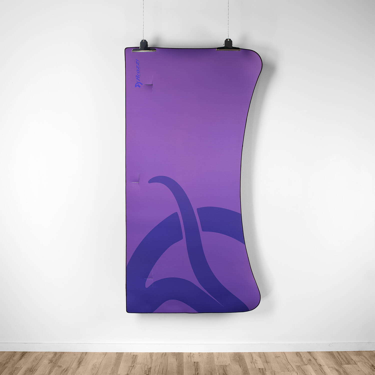 Un poster viola con un disegno viola scuro è appeso a una parete bianca.