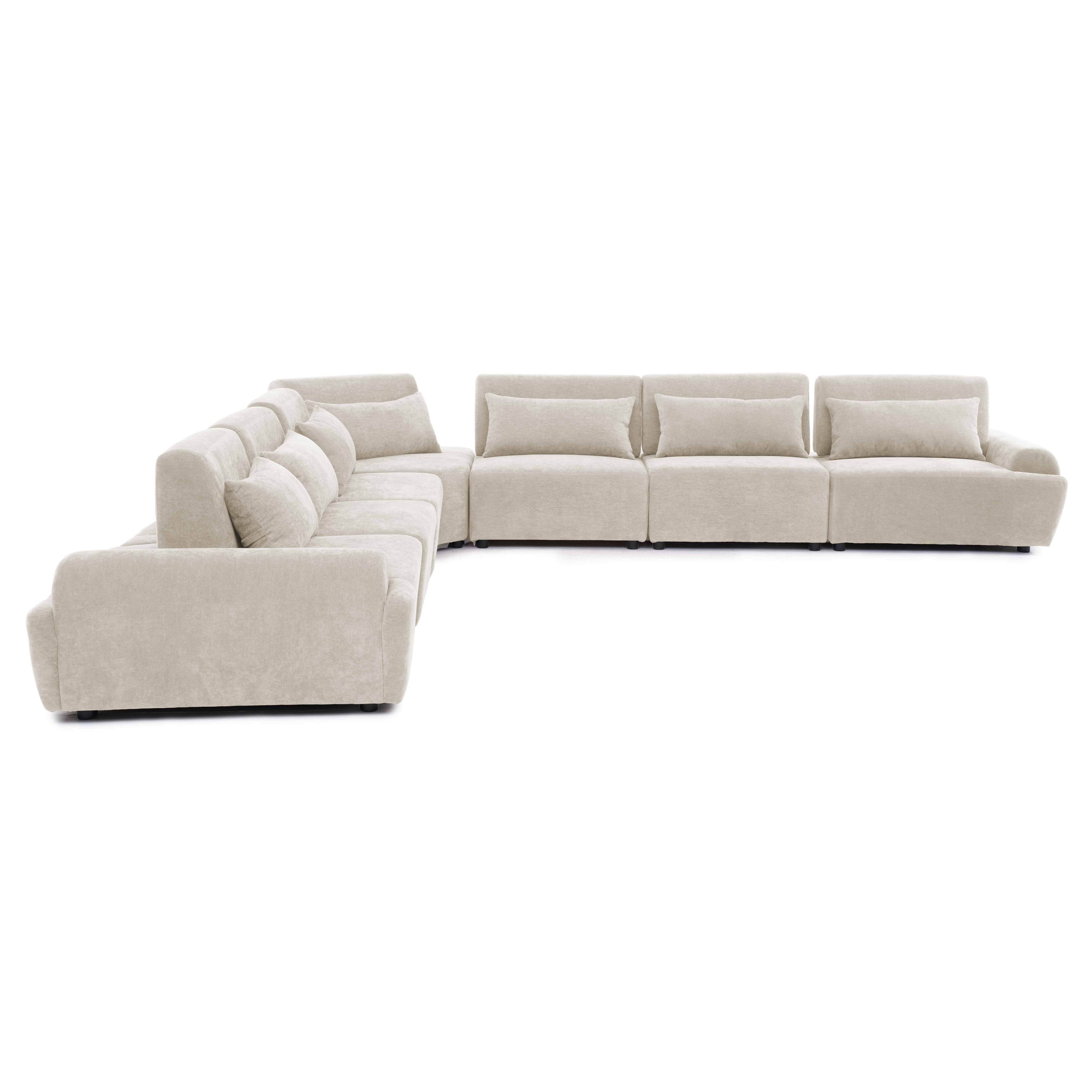 Ein beiger Ecksofa mit vielen Kissen, auf weißem Hintergrund.