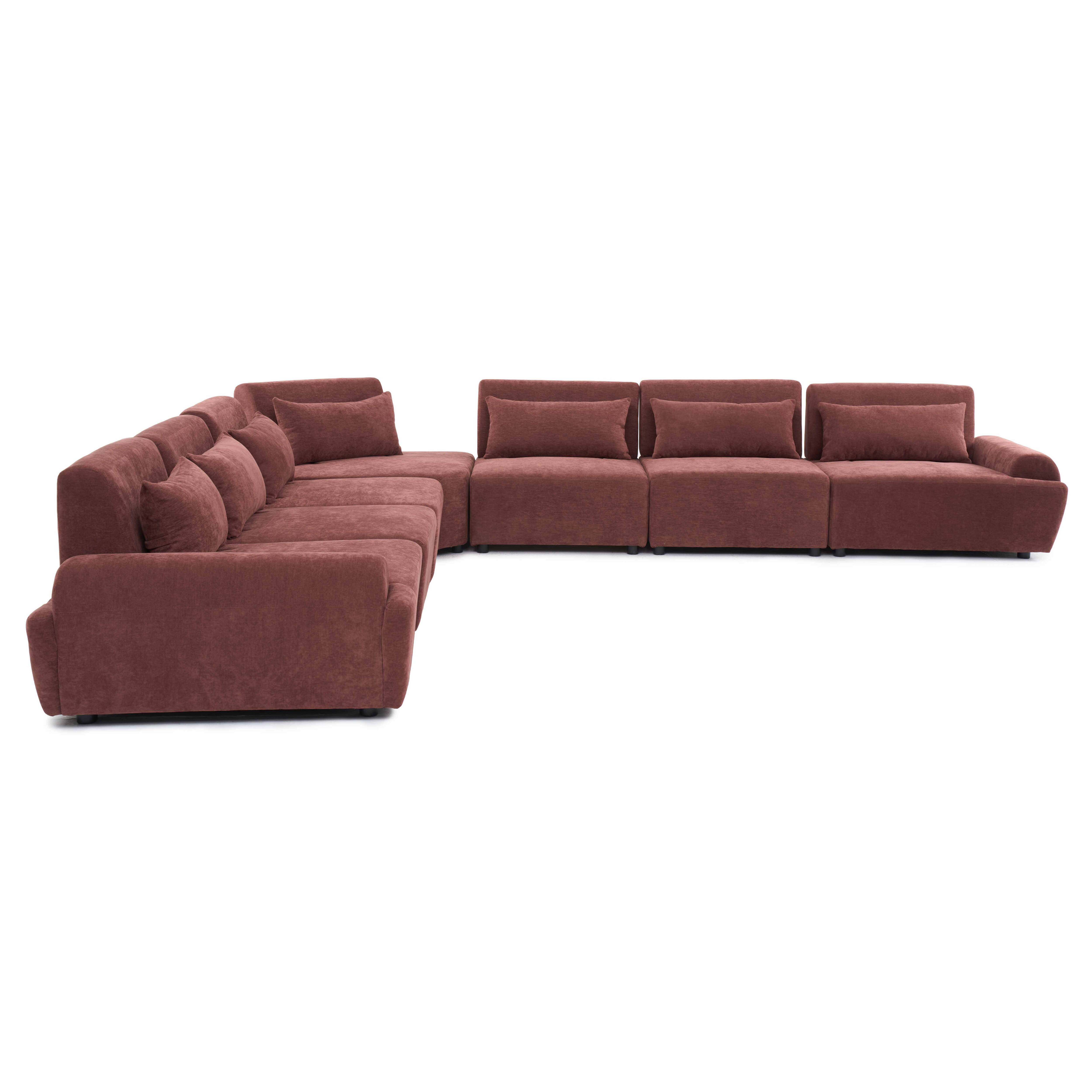 Ein brauner Ecksofa mit vielen Kissen steht auf weißem Hintergrund.