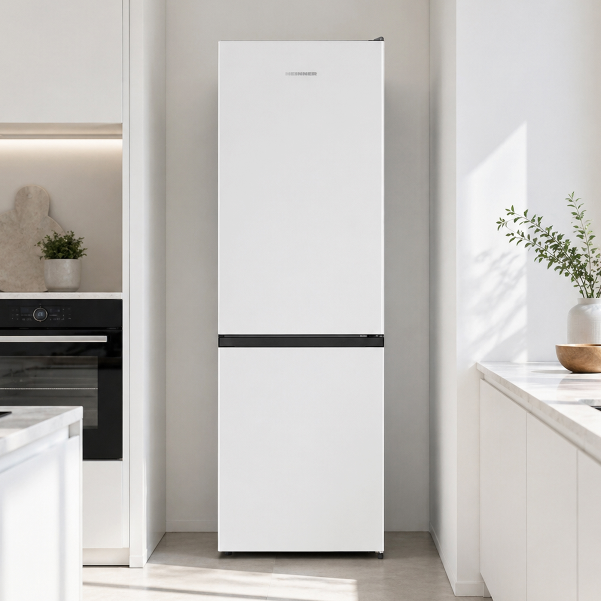 Een witte koelkast met vriesvak staat in een moderne keuken naast een oven.